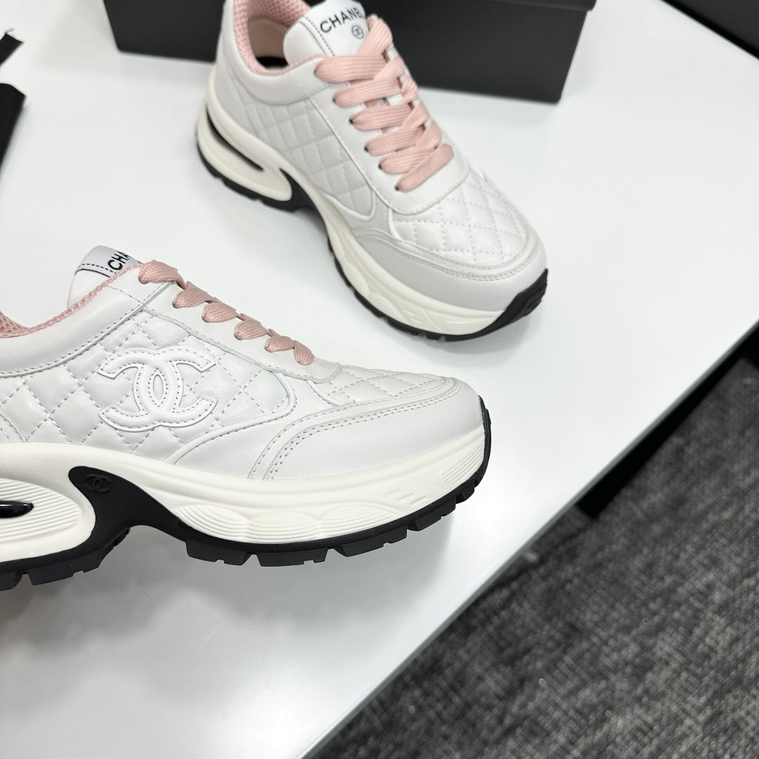 Pair of Chanel white quilted leather sneakers with pink laces and platform soles on a black box - Hình 2