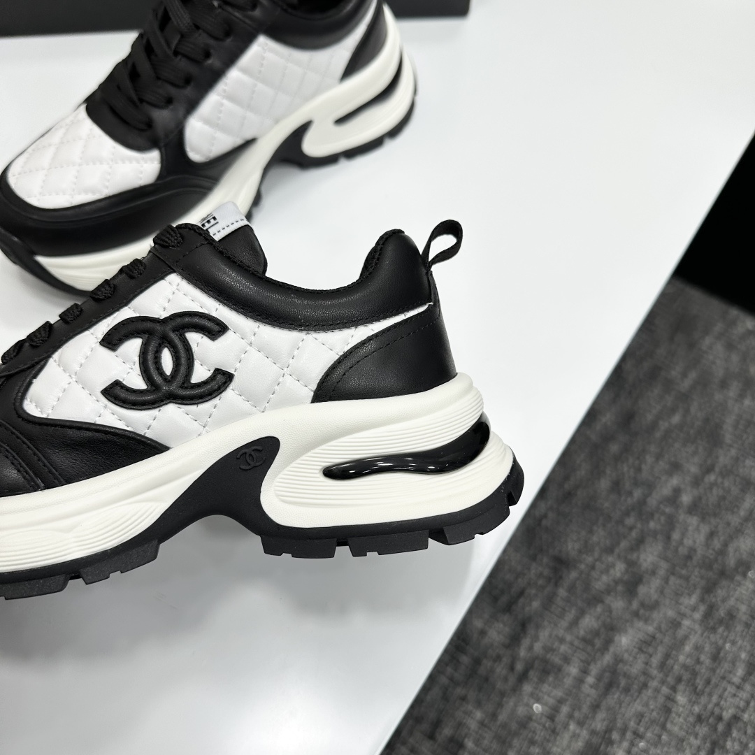 Side view of Chanel quilted leather sneakers in black and white featuring the iconic CC logo and chunky platform sole - Hình 7