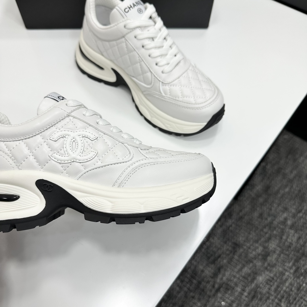 Side view of Chanel white quilted leather chunky sneakers with CC logo and platform sole on a black box. - Hình 10