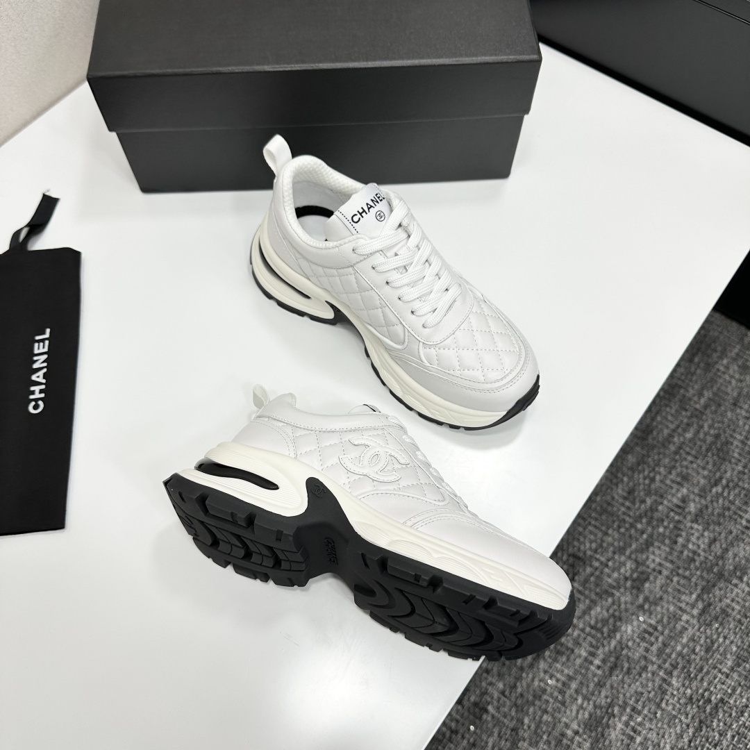 Side view of Chanel white quilted leather chunky sneakers with CC logo and platform sole on a black box. - Hình 9