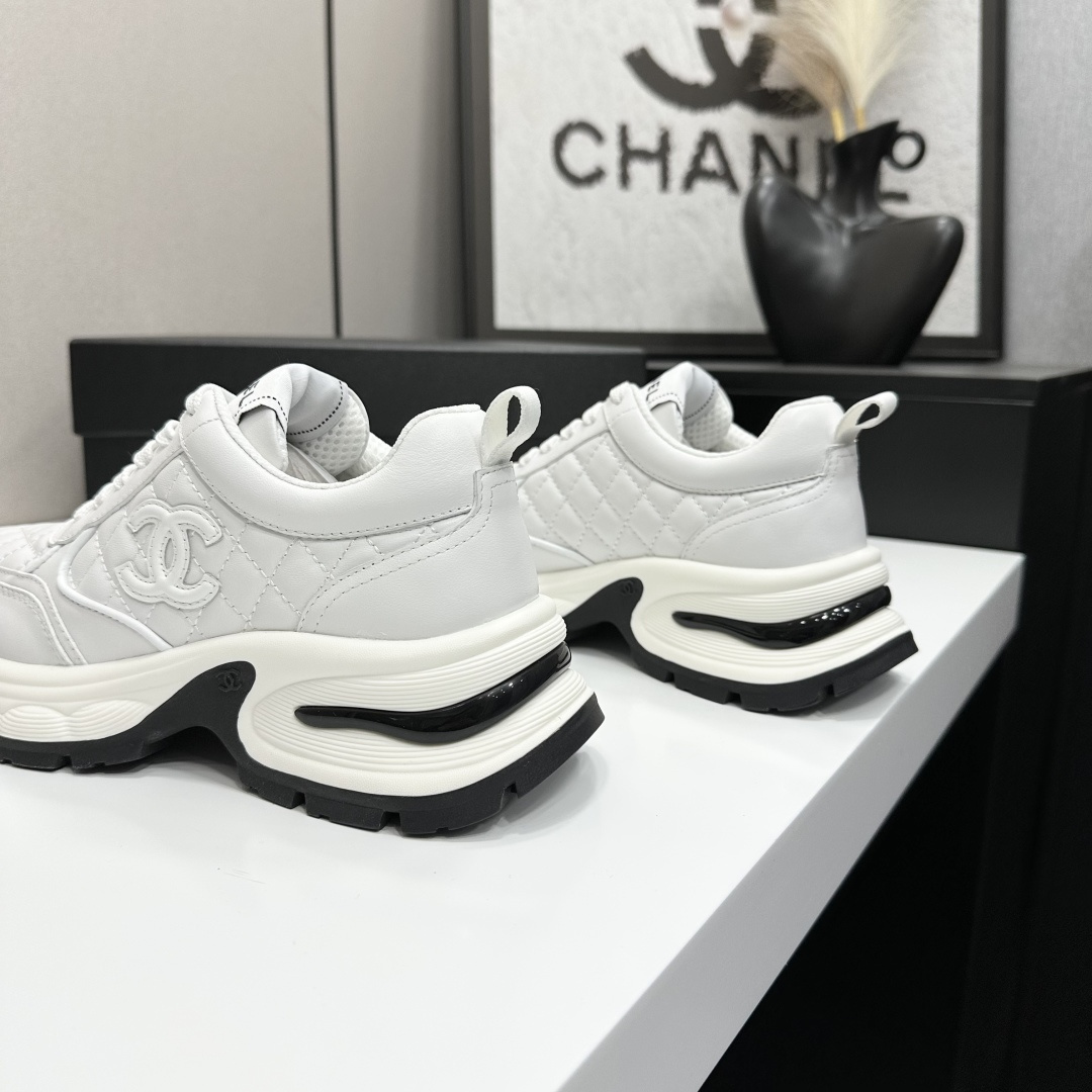 Side view of Chanel white quilted leather chunky sneakers with CC logo and platform sole on a black box. - Hình 8