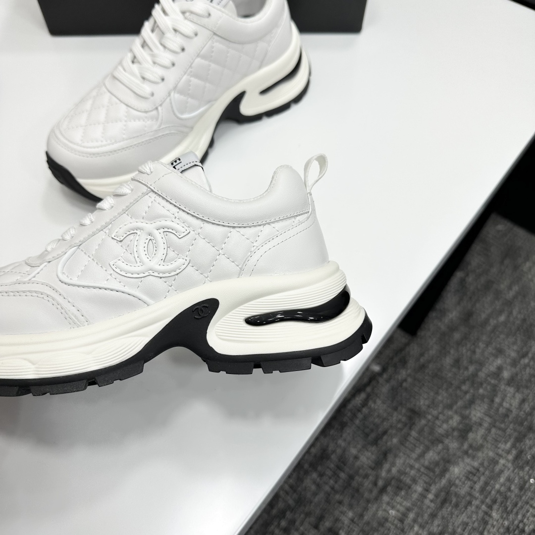 Side view of Chanel white quilted leather chunky sneakers with CC logo and platform sole on a black box. - Hình 7