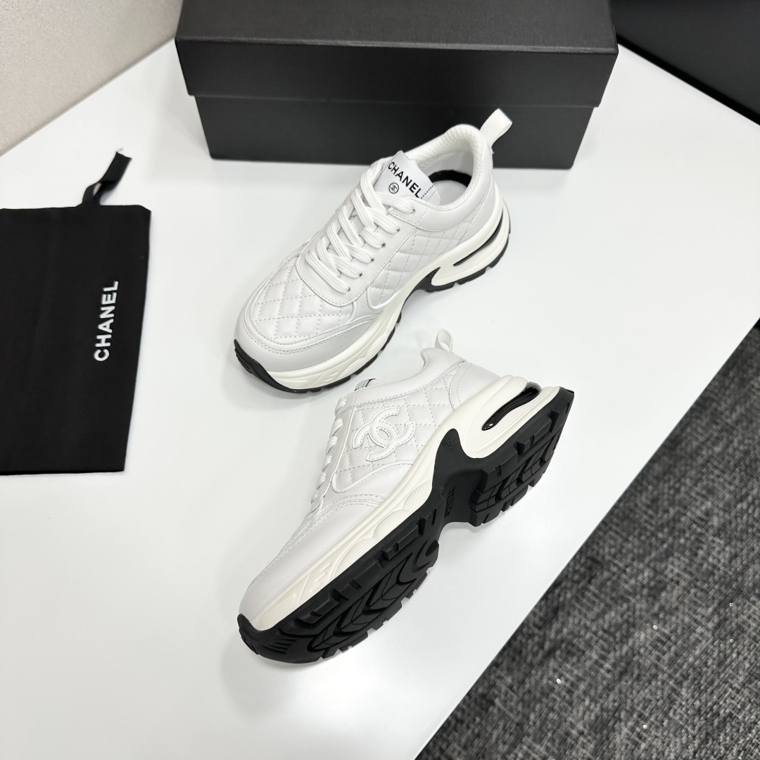 Side view of Chanel white quilted leather chunky sneakers with CC logo and platform sole on a black box. - Hình 6