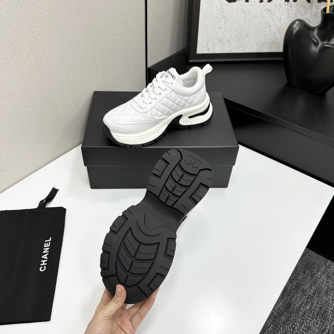 Side view of Chanel white quilted leather chunky sneakers with CC logo and platform sole on a black box. - Hình 5