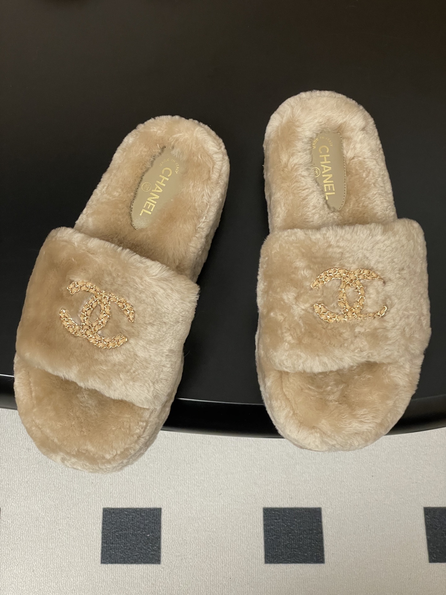 A pair of beige Chanel faux fur platform slides with gold-tone chain CC logo on the strap - Hình 2