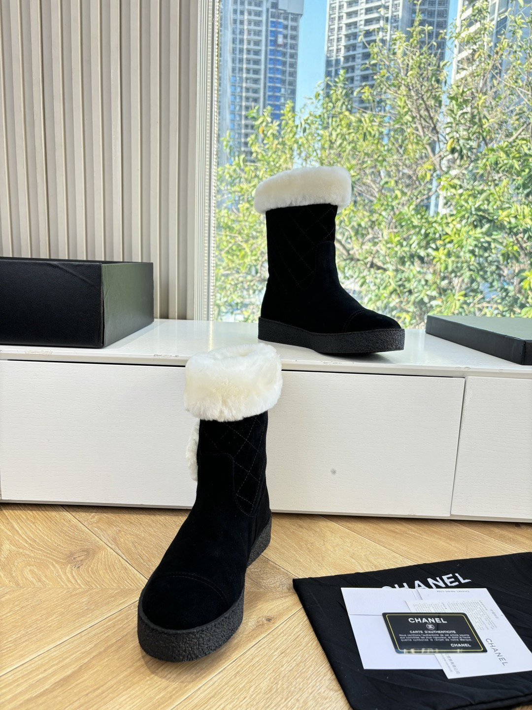 A pair of black suede winter boots with white faux fur trim and a circular fur logo on a white surface - Hình 5