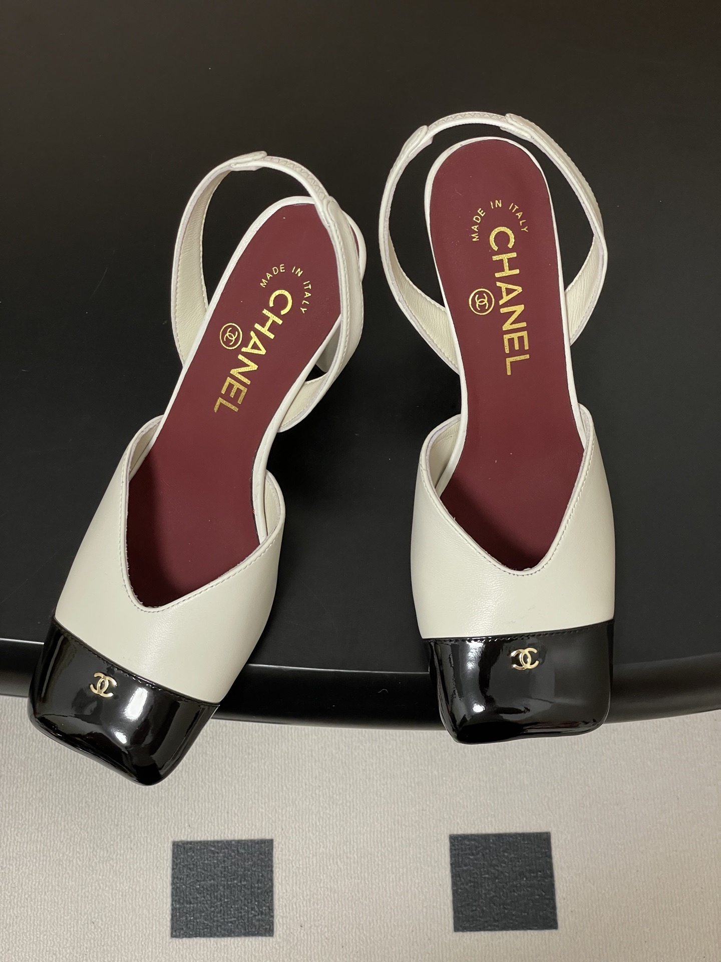 A pair of Chanel two-tone slingback pumps in white and black leather with a square toe and block heel - Hình 2