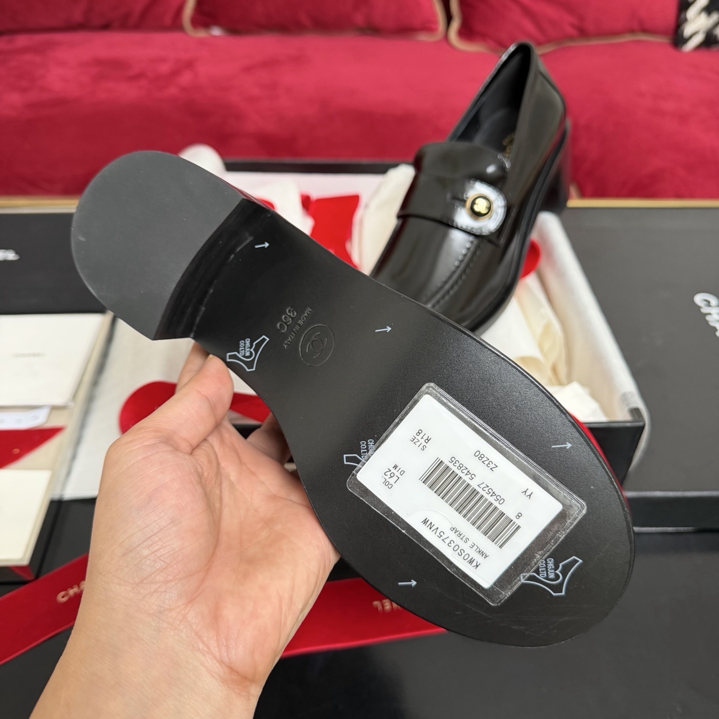 Luxury black Chanel patent leather loafers with gold CC logo buttons displayed in a box with red ribbons - Hình 9