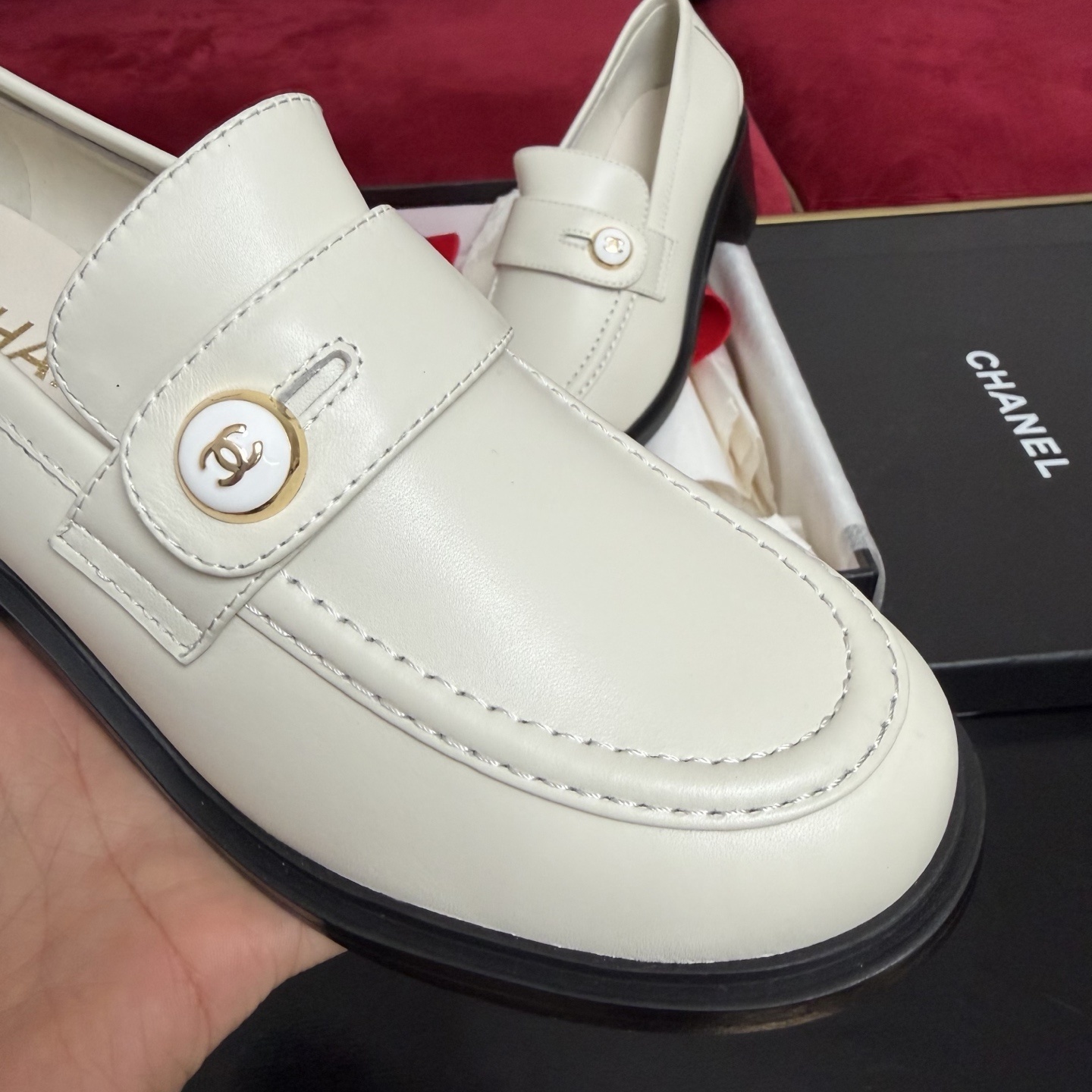 Pair of cream Chanel leather loafers with gold CC logo button and black block heel in original luxury packaging - Hình 6