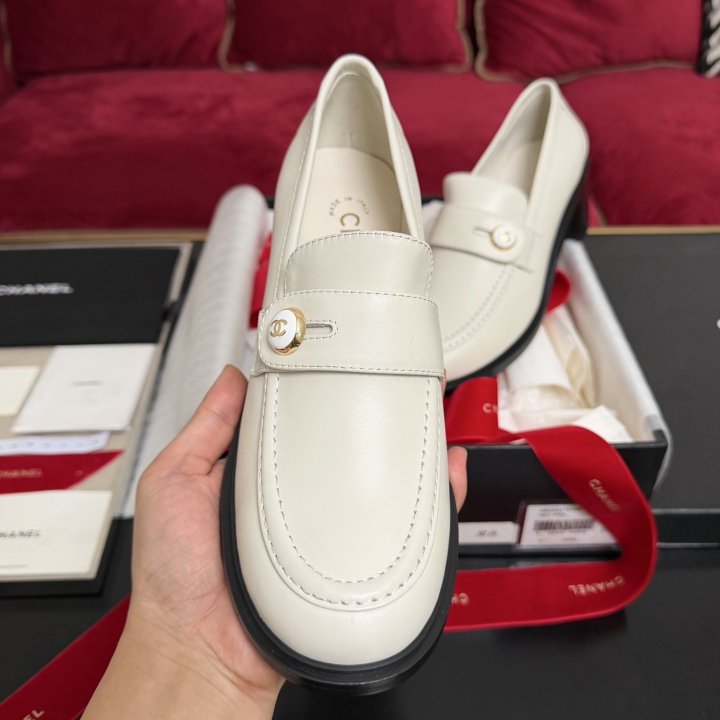 Pair of cream Chanel leather loafers with gold CC logo button and black block heel in original luxury packaging - Hình 3