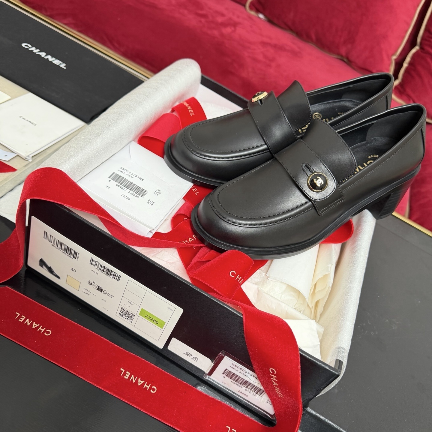 Authentic Chanel black leather loafers with block heels and gold CC logo buttons displayed in a box - Hình 2