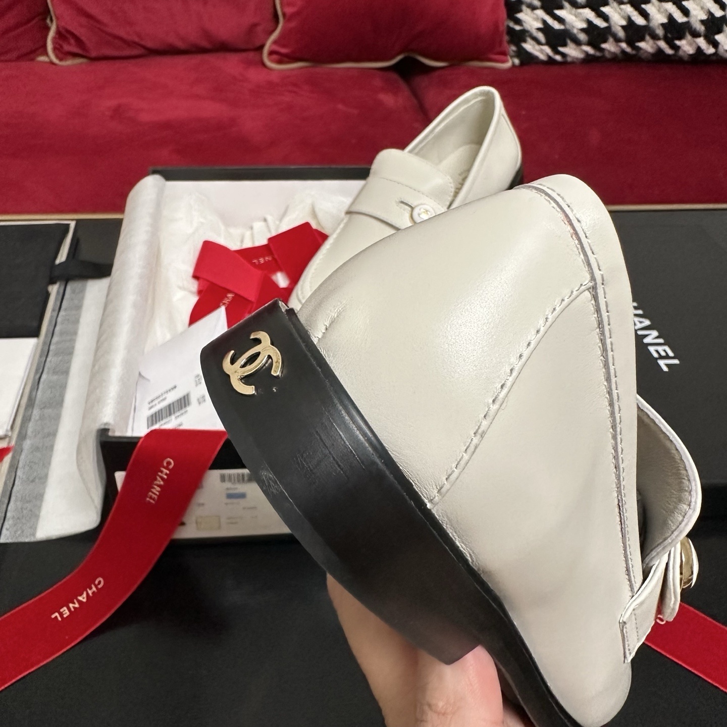 Pair of ivory Chanel leather loafers with gold CC logo buttons in original packaging with red ribbons. - Hình 8