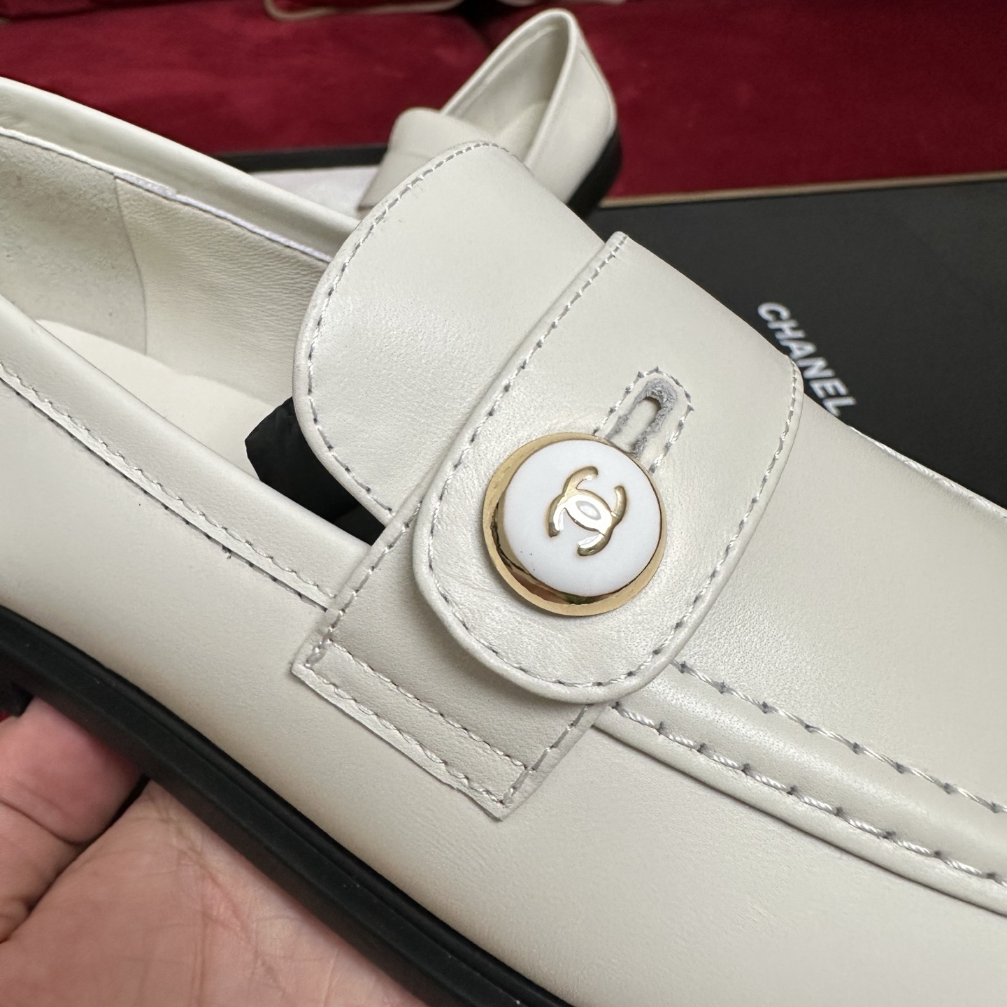 Pair of ivory Chanel leather loafers with gold CC logo buttons in original packaging with red ribbons. - Hình 7