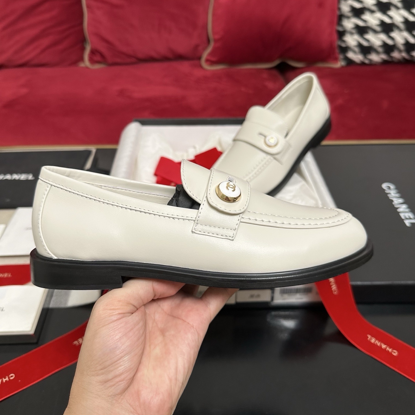 Pair of ivory Chanel leather loafers with gold CC logo buttons in original packaging with red ribbons. - Hình 5