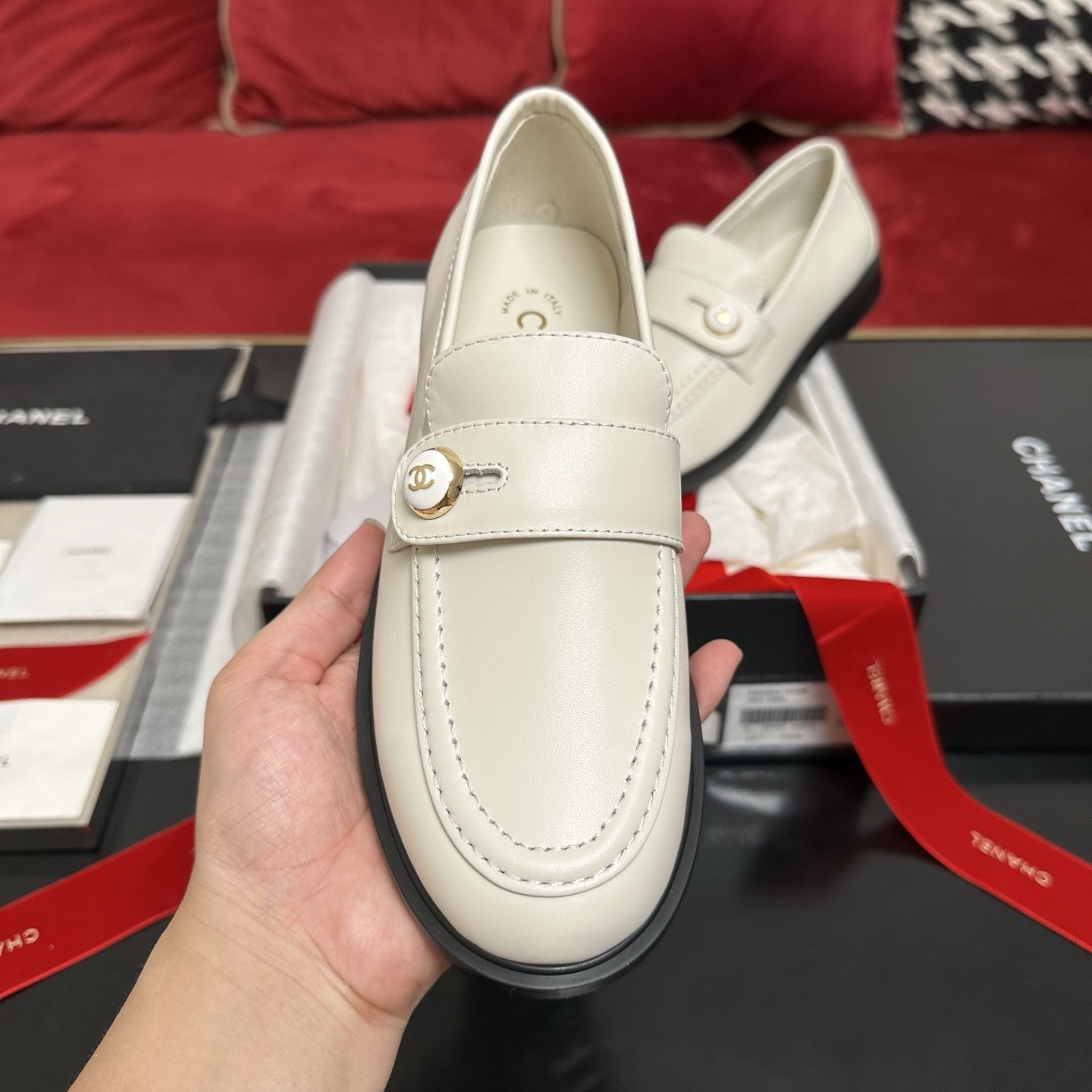Pair of ivory Chanel leather loafers with gold CC logo buttons in original packaging with red ribbons. - Hình 3