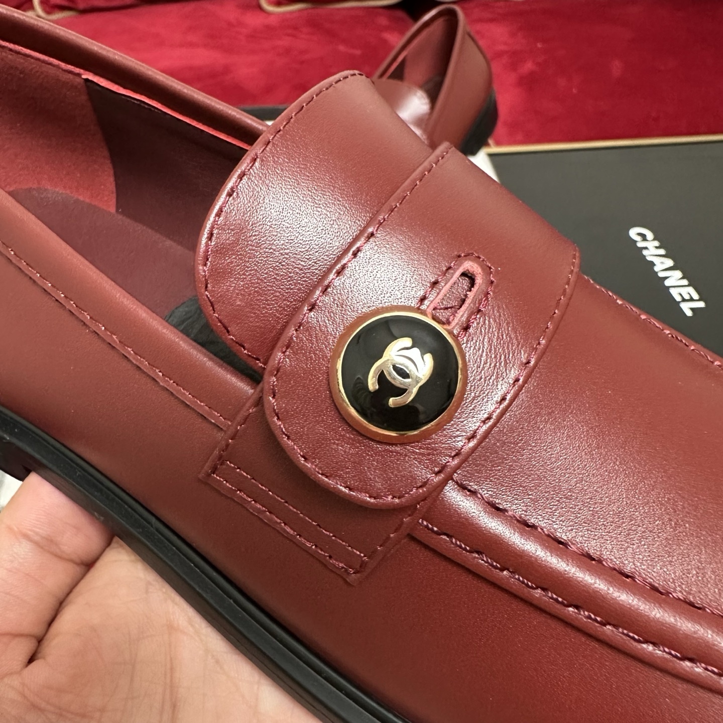 Luxury Chanel burgundy leather loafers with gold CC logo button displayed with designer packaging and red ribbons - Hình 7