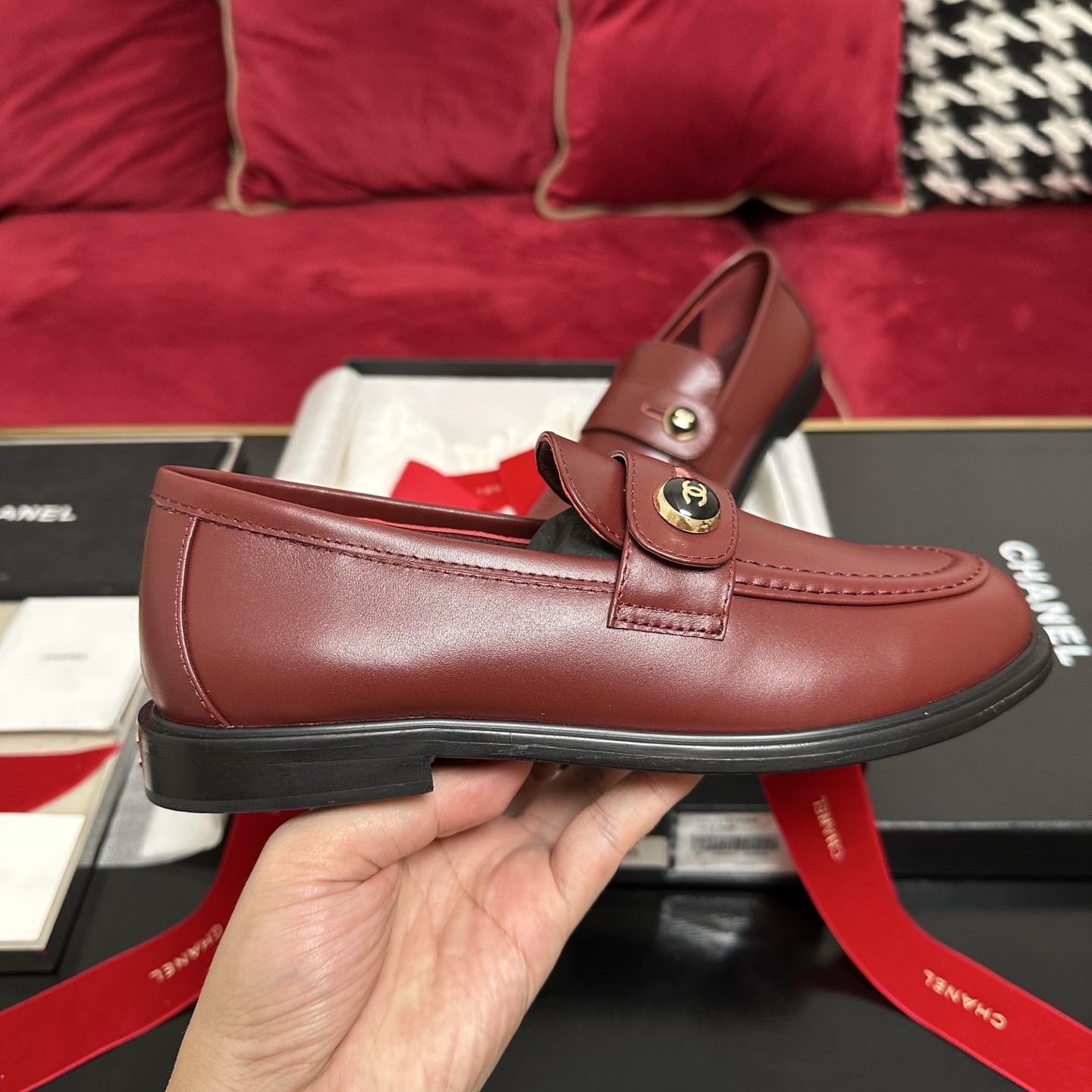 Luxury Chanel burgundy leather loafers with gold CC logo button displayed with designer packaging and red ribbons - Hình 5