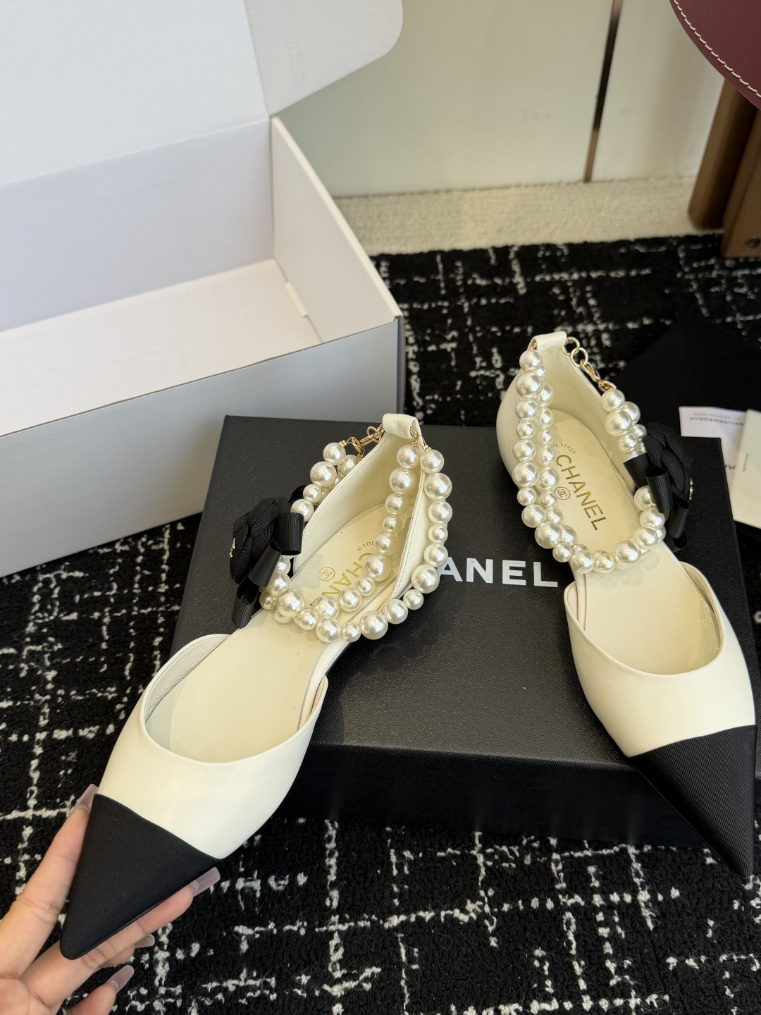 Chanel two-tone cream and black pointed-toe flats with double-strand pearl ankle straps and a black camellia flower detail. - Hình 6