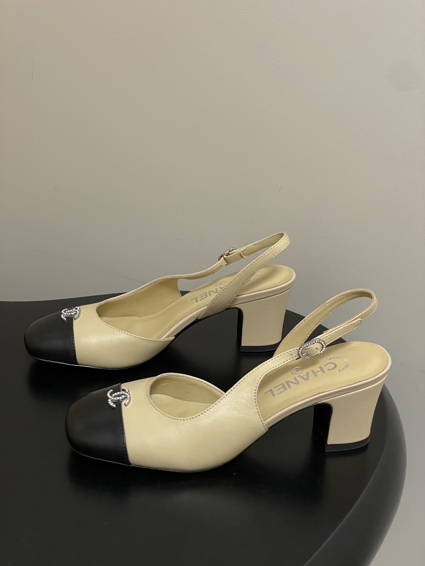 A pair of Chanel two-tone beige and black leather slingback pumps with crystal CC logo on the toe cap - Hình 3