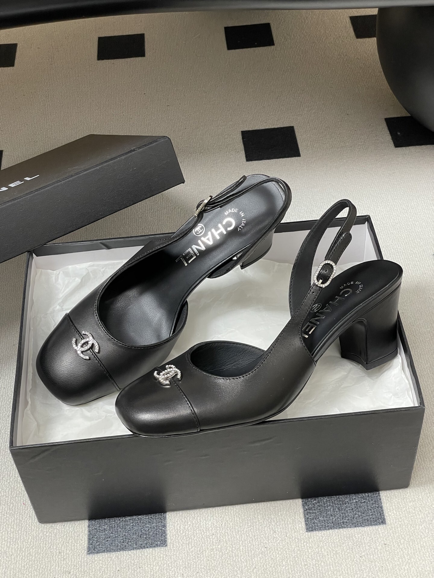 A pair of luxury black leather Chanel slingback pumps with crystal CC logos on the toes and block heels. - Hình 4