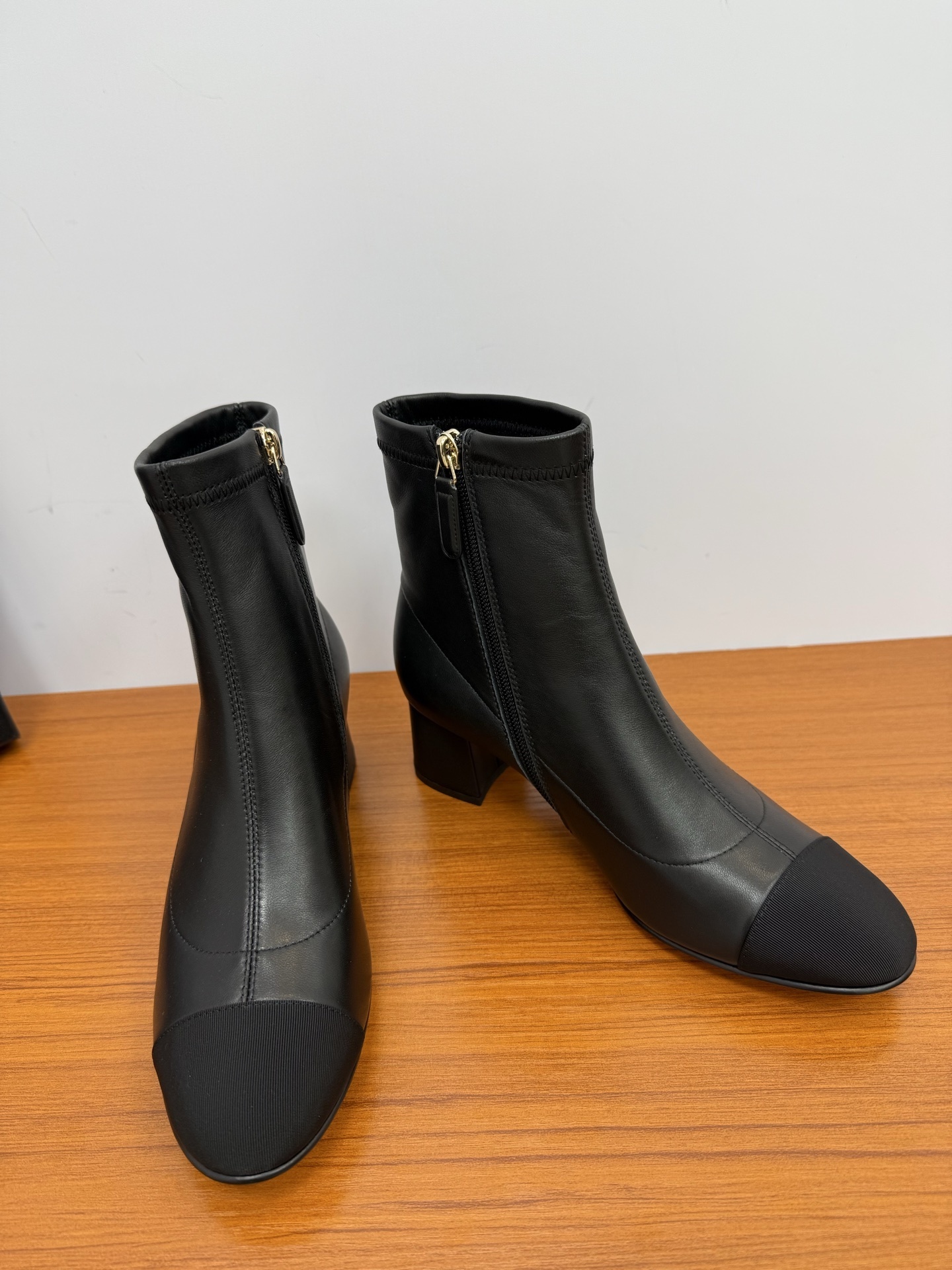 Elegant black leather ankle boots with a fabric cap toe and gold-tone zipper detail - Hình 7