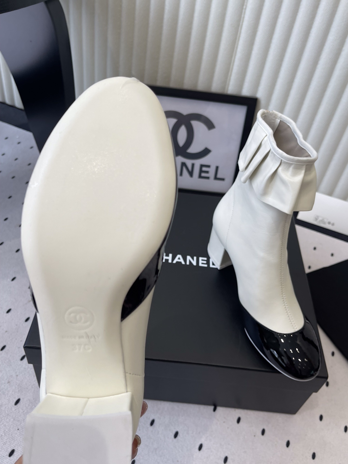 Chanel two-tone white and black leather ankle boots with ruffle collar and block heel on a black box. - Hình 9