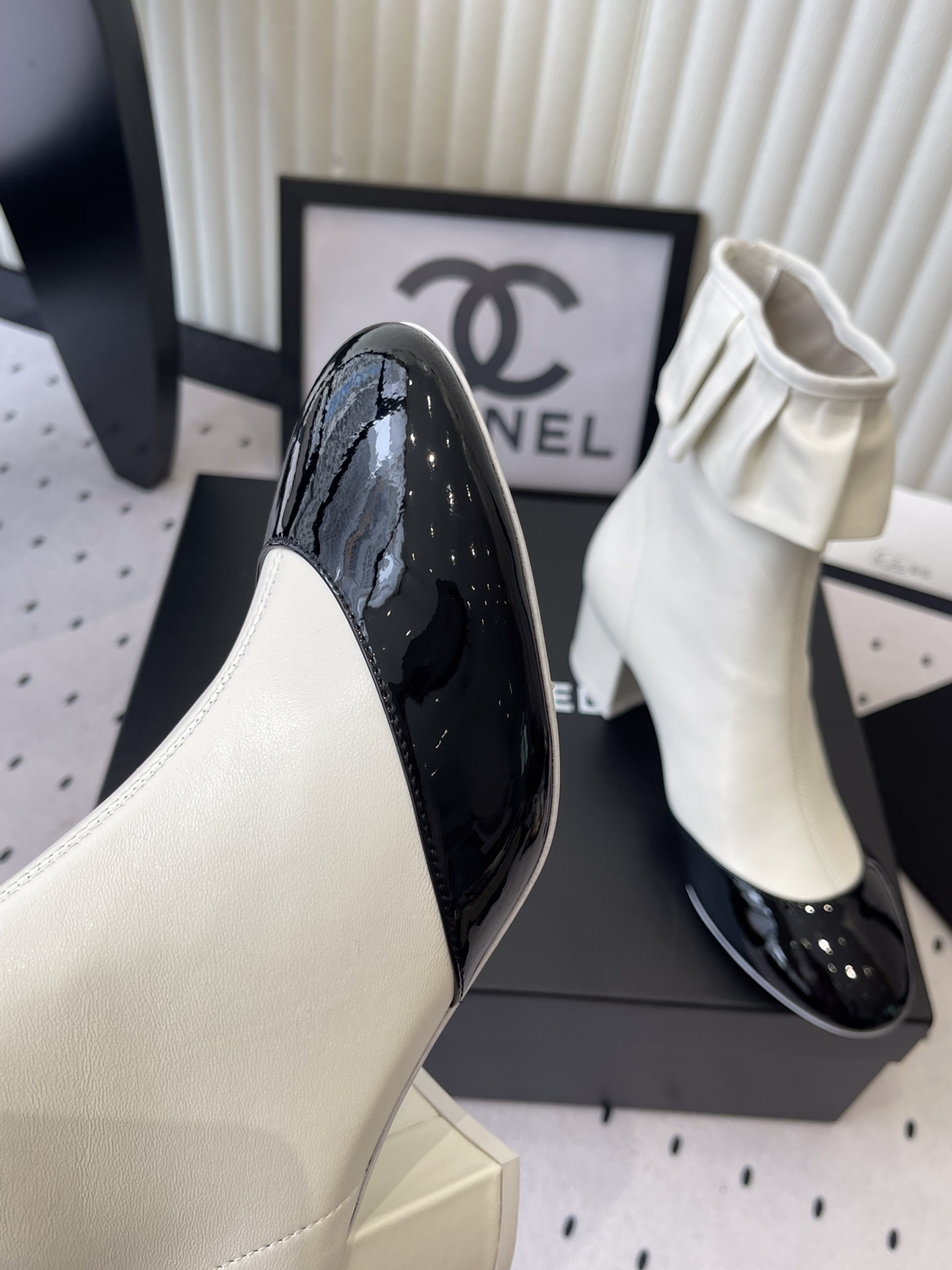 Chanel two-tone white and black leather ankle boots with ruffle collar and block heel on a black box. - Hình 6
