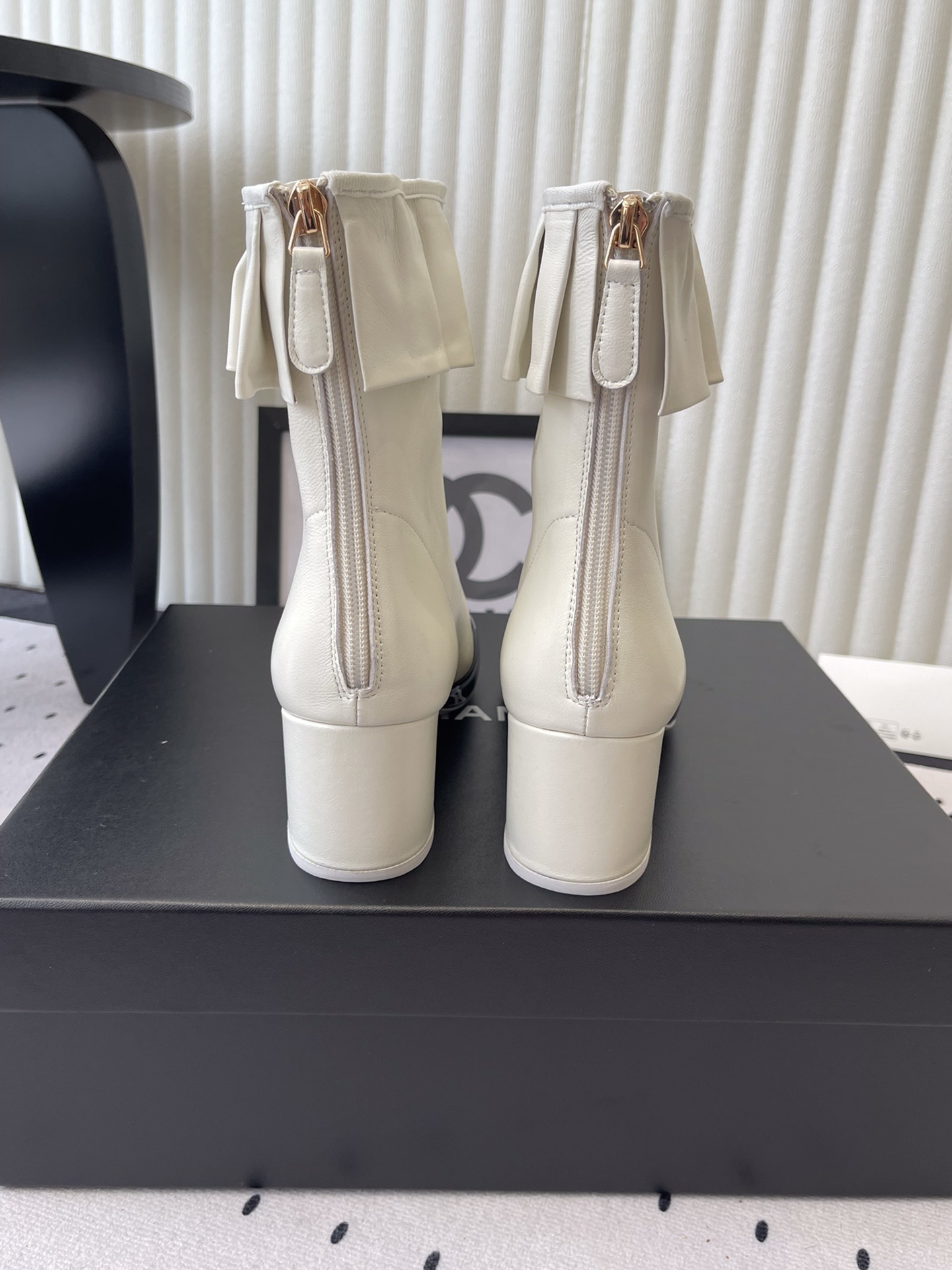 Chanel two-tone white and black leather ankle boots with ruffle collar and block heel on a black box. - Hình 3