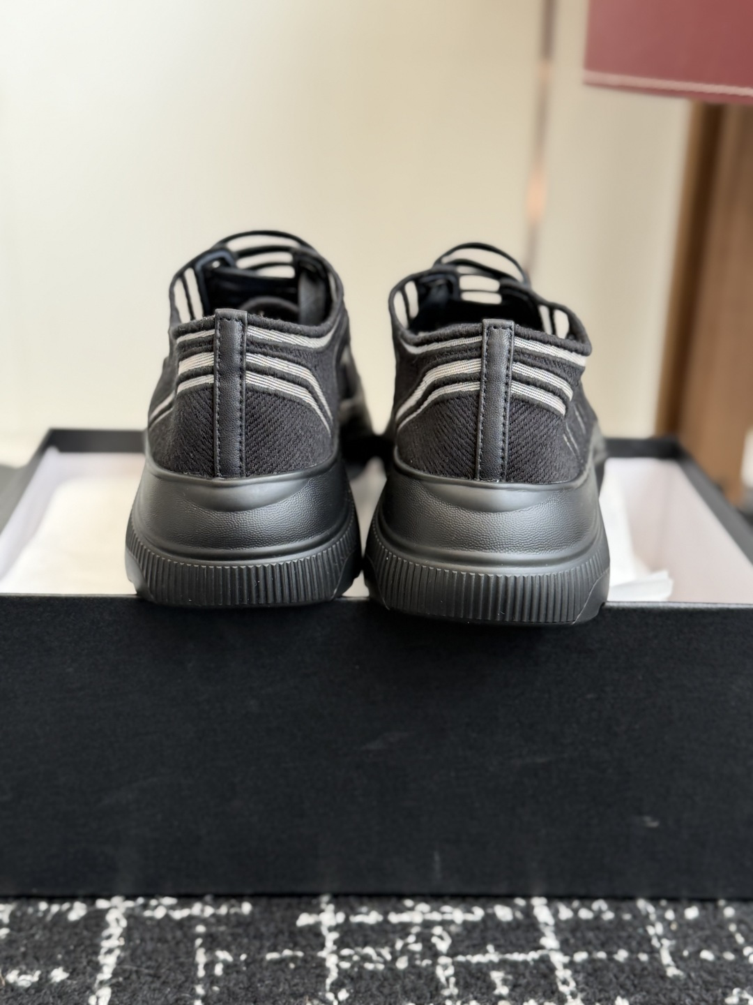 Pair of black and white Chanel mesh sneakers with wavy patterns and CC logo on a black box - Hình 8