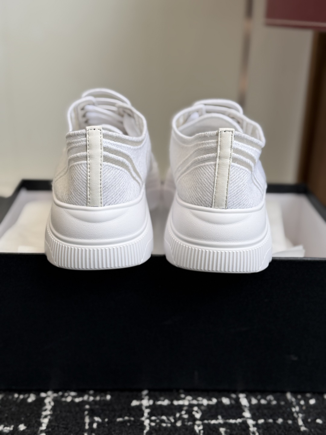 Pair of white Chanel sneakers with mesh panels and double C logo on the toe cap, placed on a black designer shoe box. - Hình 8