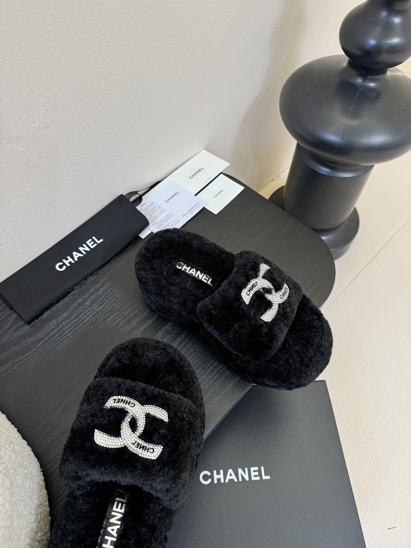 Luxury black Chanel shearling platform slides featuring crystal-embellished CC logos displayed with original packaging. - Hình 4
