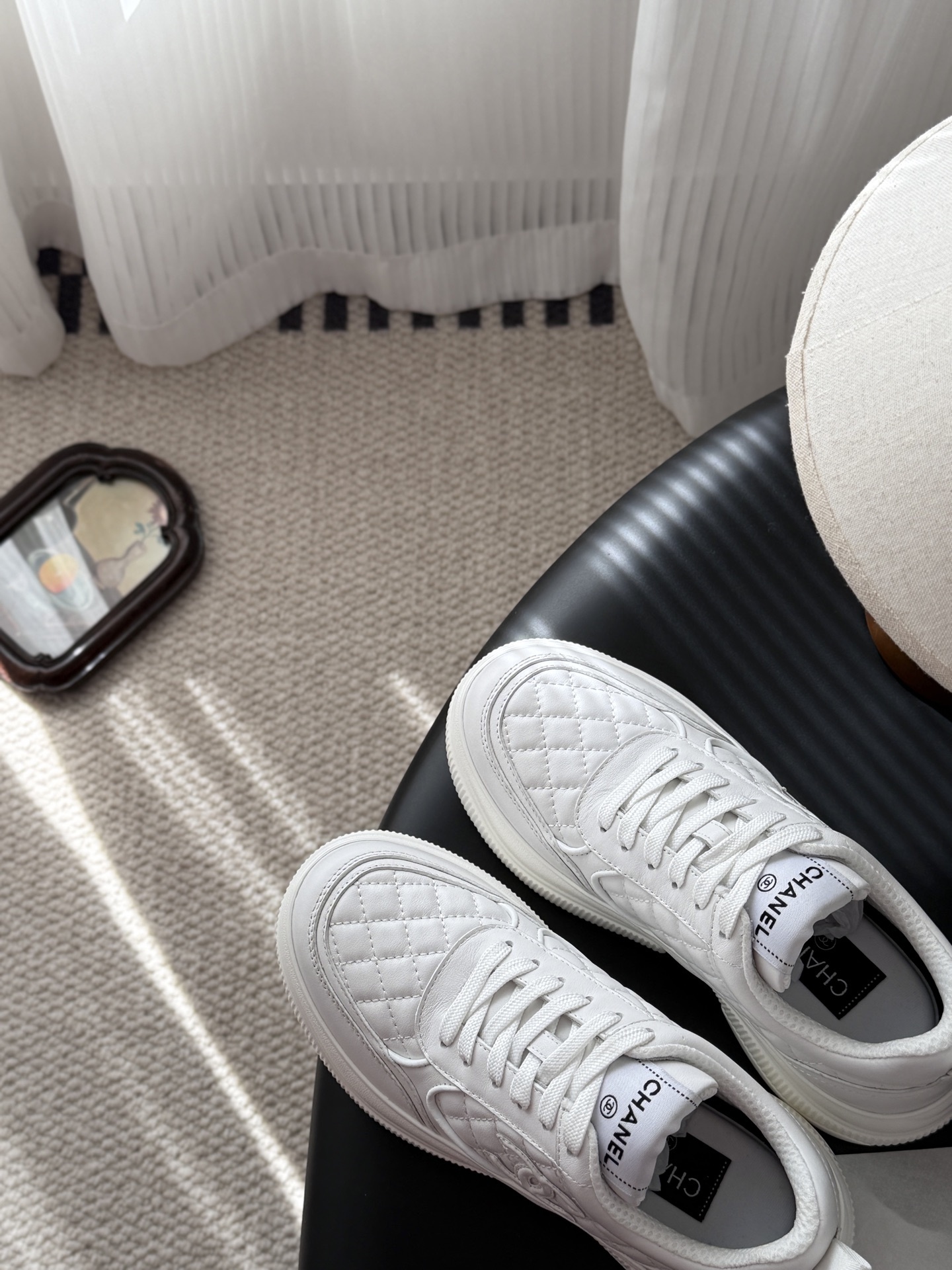 A pair of luxury Chanel white quilted leather sneakers next to their original black designer box - Hình 7