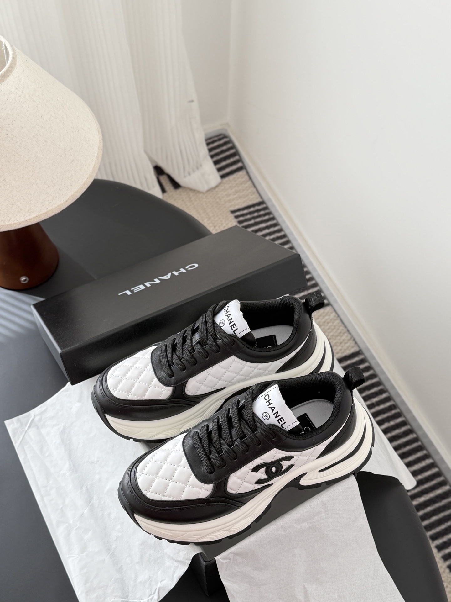 Pair of luxury Chanel women's sneakers in black and white quilted leather with chunky soles and CC logo. - Hình 9