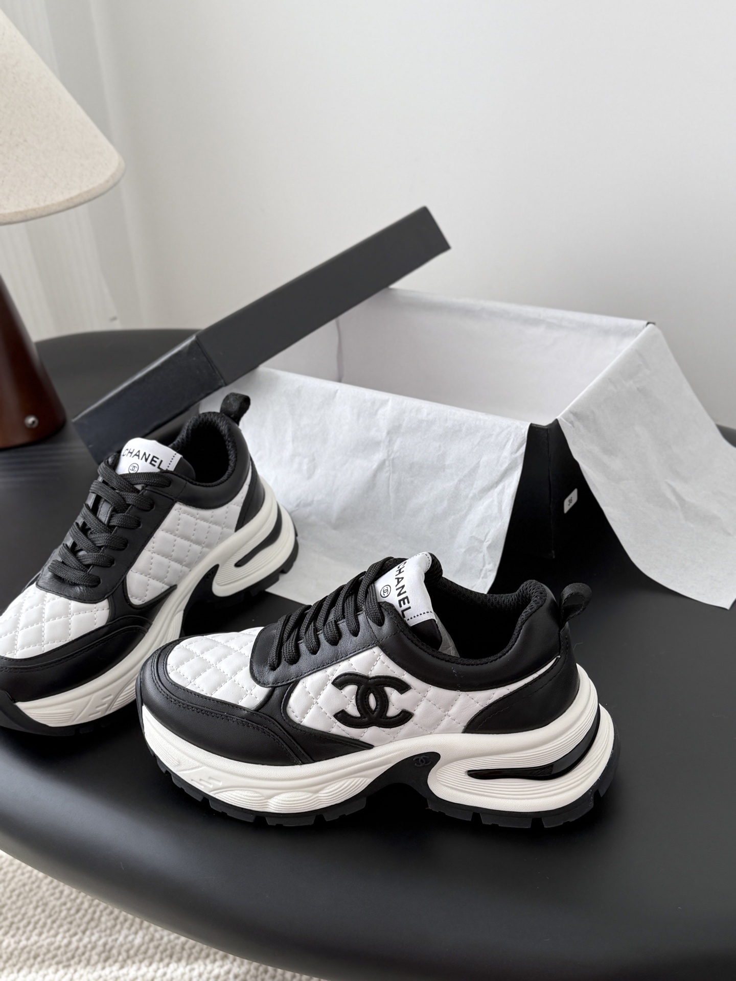 Pair of luxury Chanel women's sneakers in black and white quilted leather with chunky soles and CC logo. - Hình 2