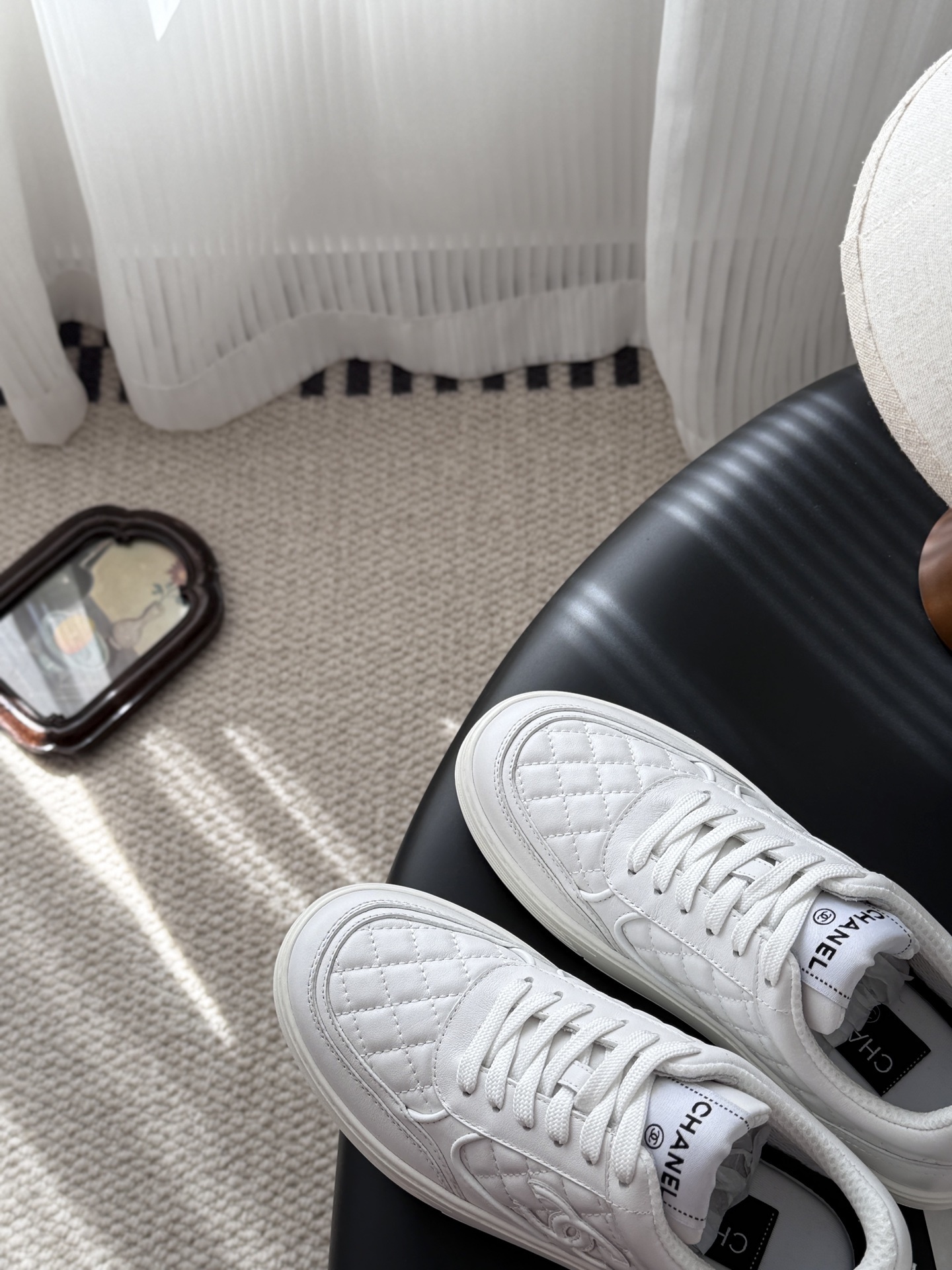 A pair of luxury Chanel white quilted leather sneakers with the CC logo next to their original black box. - Hình 7