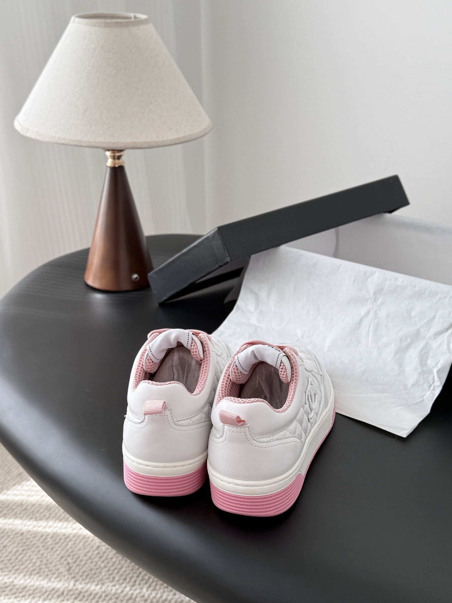 Pair of Chanel white quilted leather sneakers with pink laces and pink soles next to a black Chanel box - Hình 3