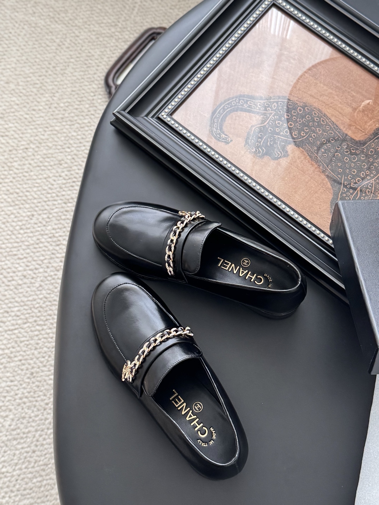 Pair of black Chanel leather loafers with gold chain and CC logo detail next to original box - Hình 5