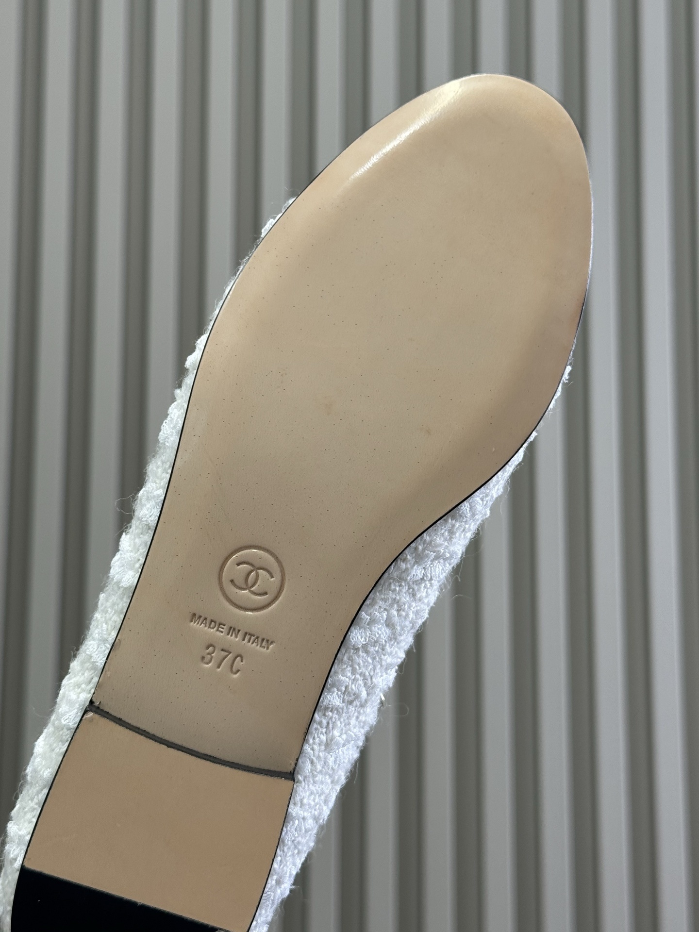 Luxury Chanel ballet flats made of white tweed and black patent leather with gold chain trim and bow detail on a black box. - Hình 6