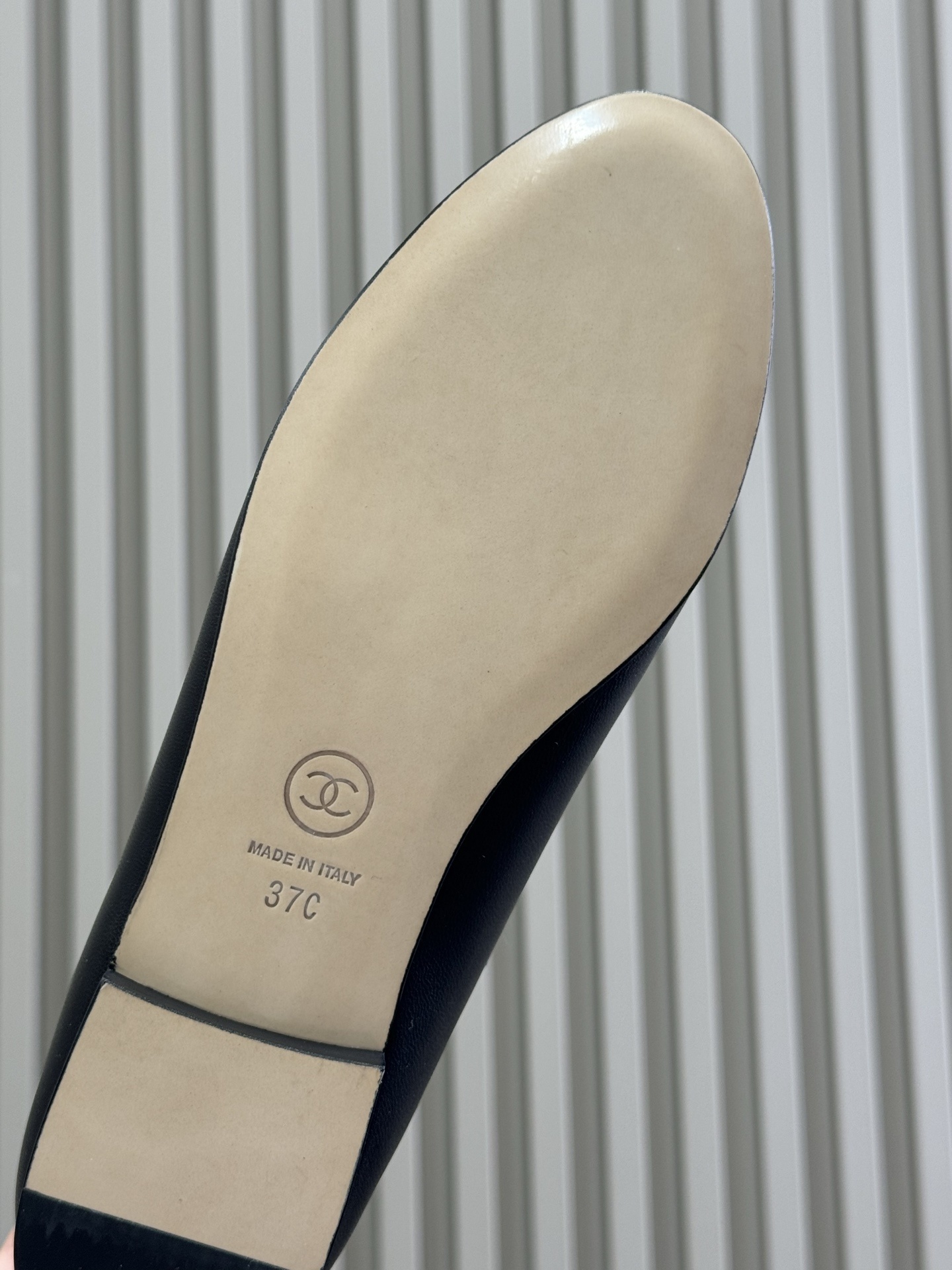 Pair of Chanel black leather ballet flats with patent cap toe and gold chain trim on a black box - Hình 6