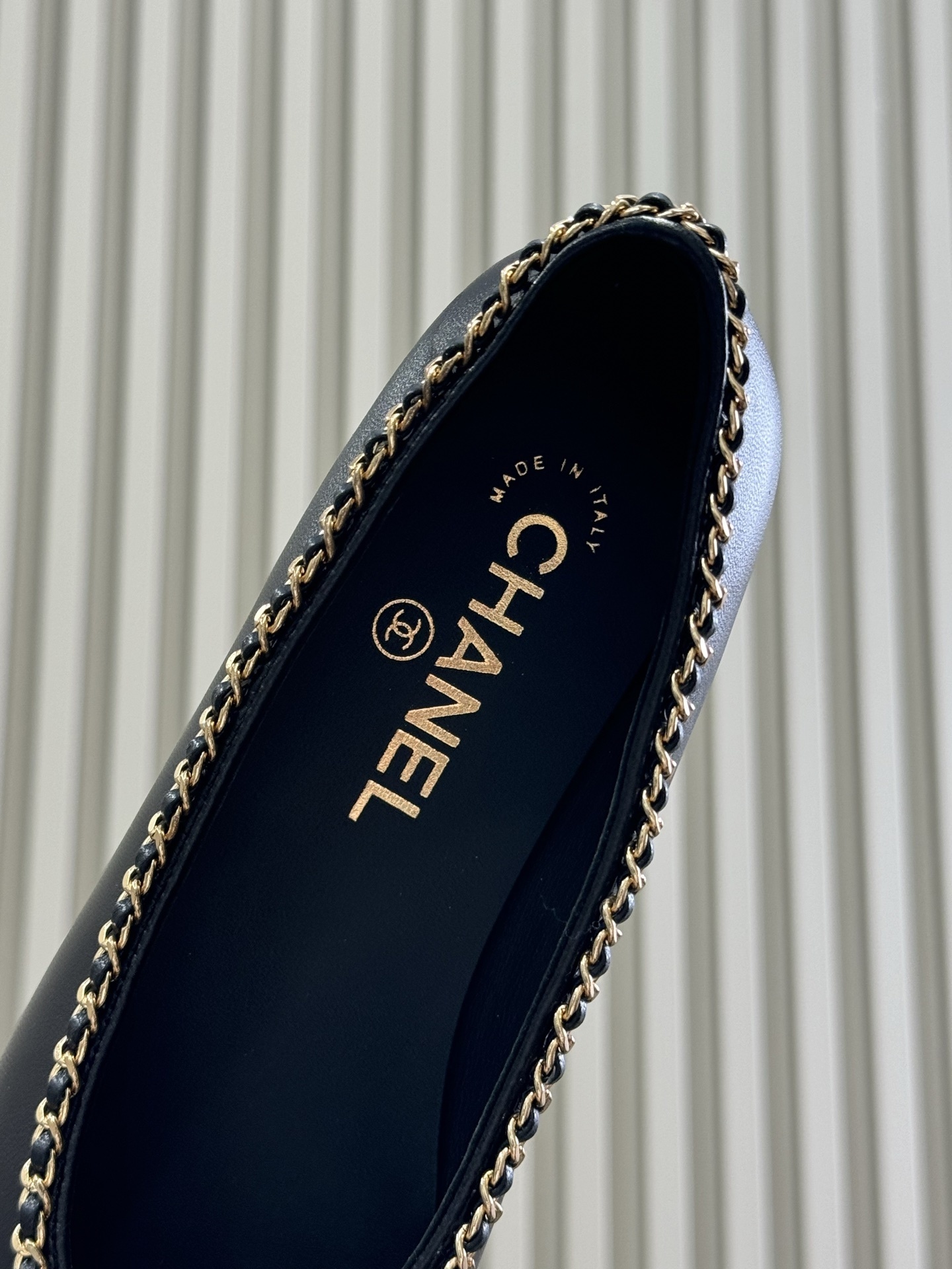 Pair of Chanel black leather ballet flats with patent cap toe and gold chain trim on a black box - Hình 5