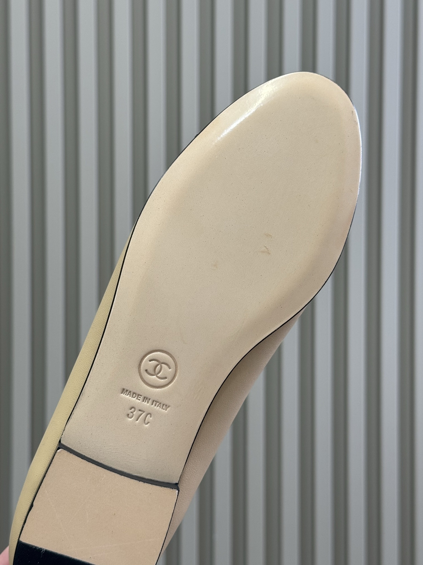 Pair of luxury beige leather ballet flats with black patent leather cap toes and gold chain link bow detailing - Hình 6