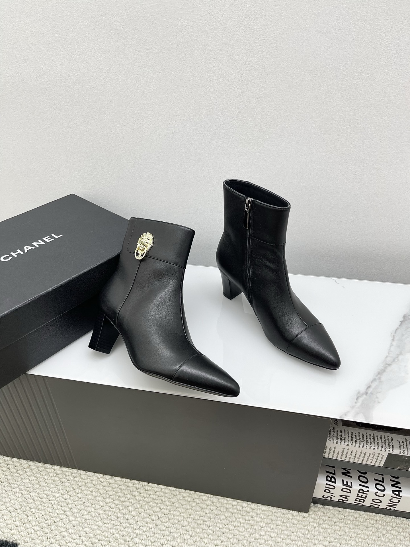 Chanel black leather pointed-toe ankle boots with side zippers and block heels shown next to a signature Chanel box. - Hình 4