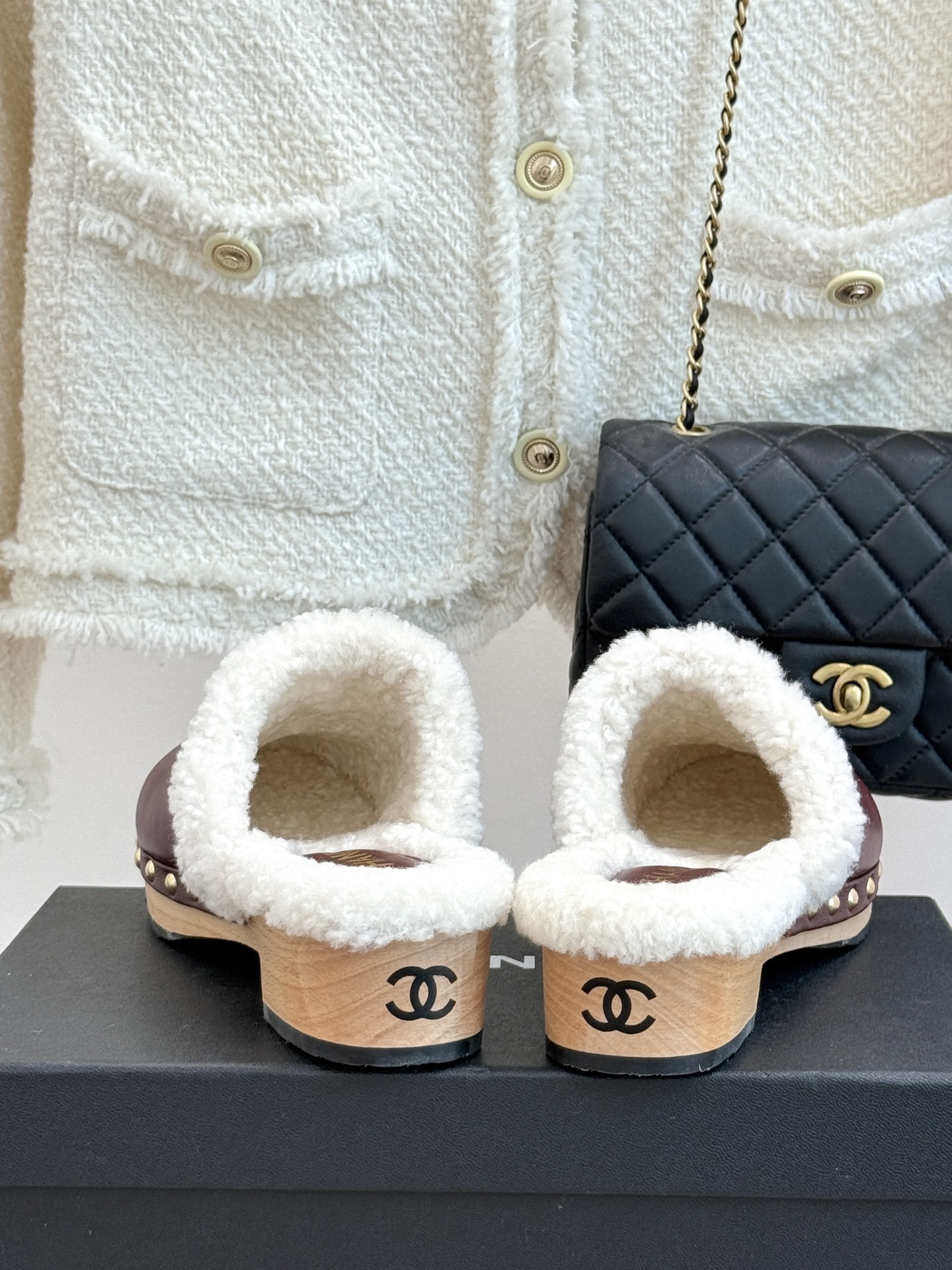 Pair of burgundy Chanel leather clogs with white shearling lining and gold CC logo on a black box - Hình 6