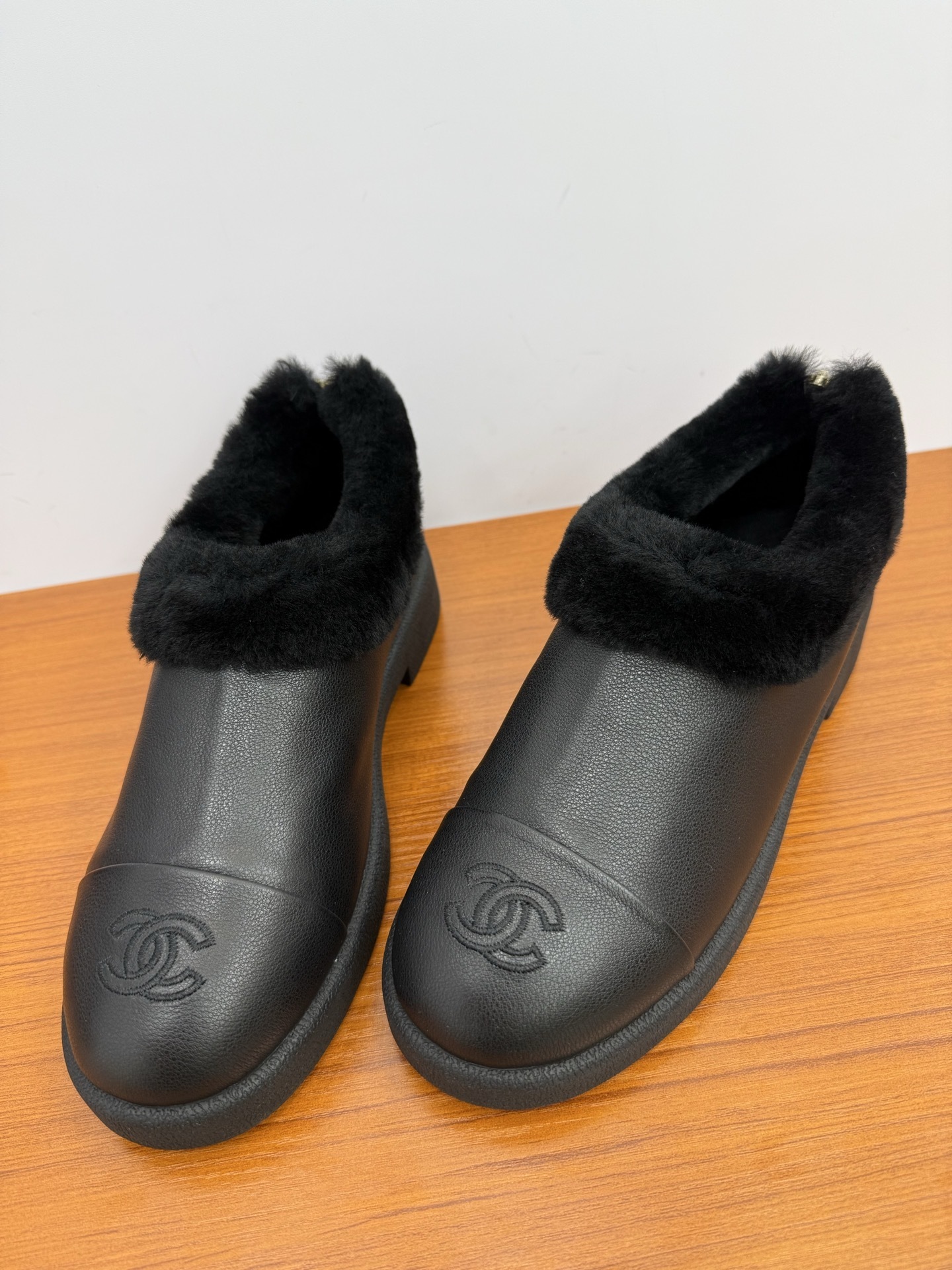 Pair of black leather women's mules with thick black fur lining and embroidered CC logo on the toe - Hình 6