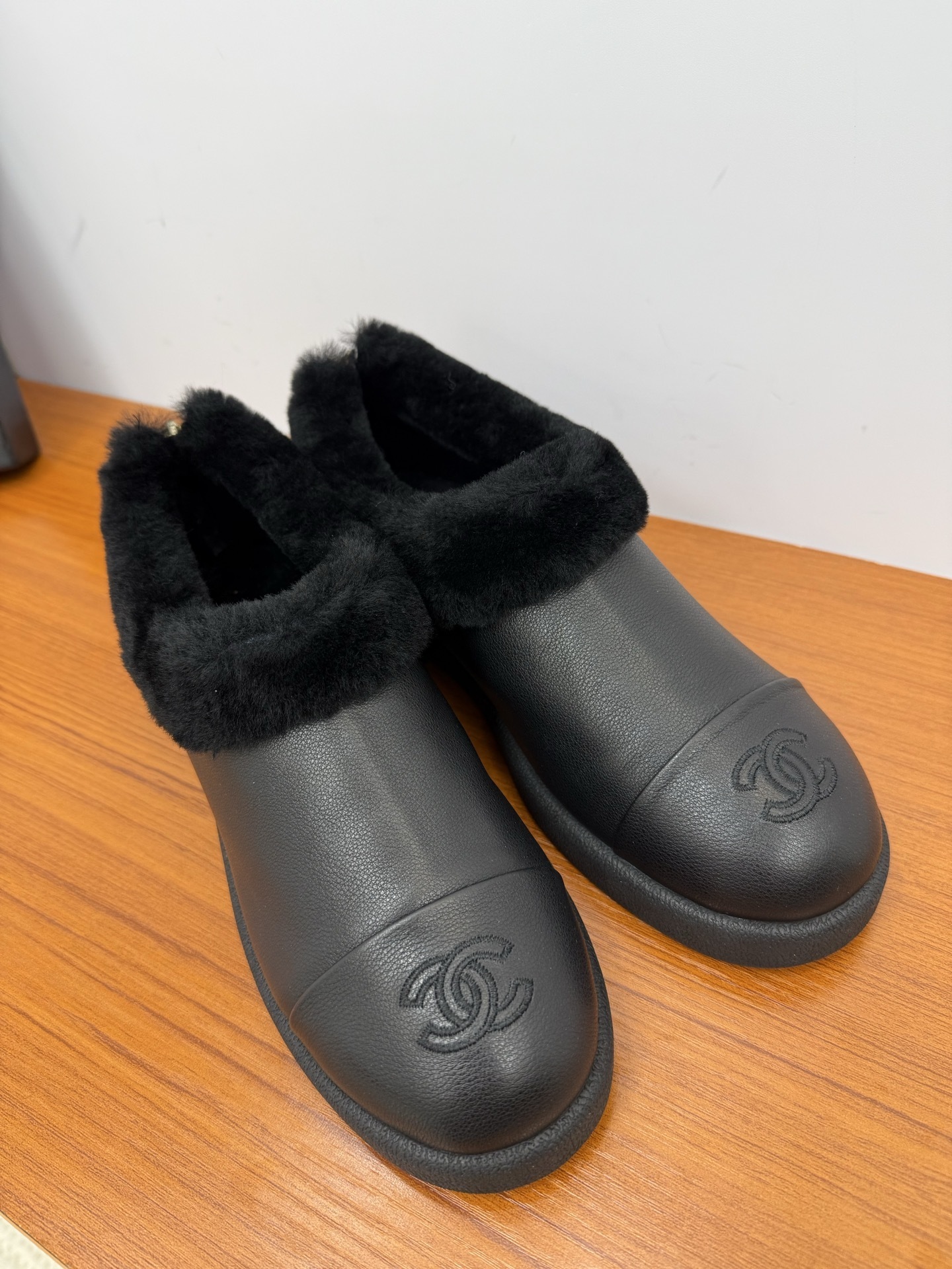 Pair of black leather women's mules with thick black fur lining and embroidered CC logo on the toe - Hình 4