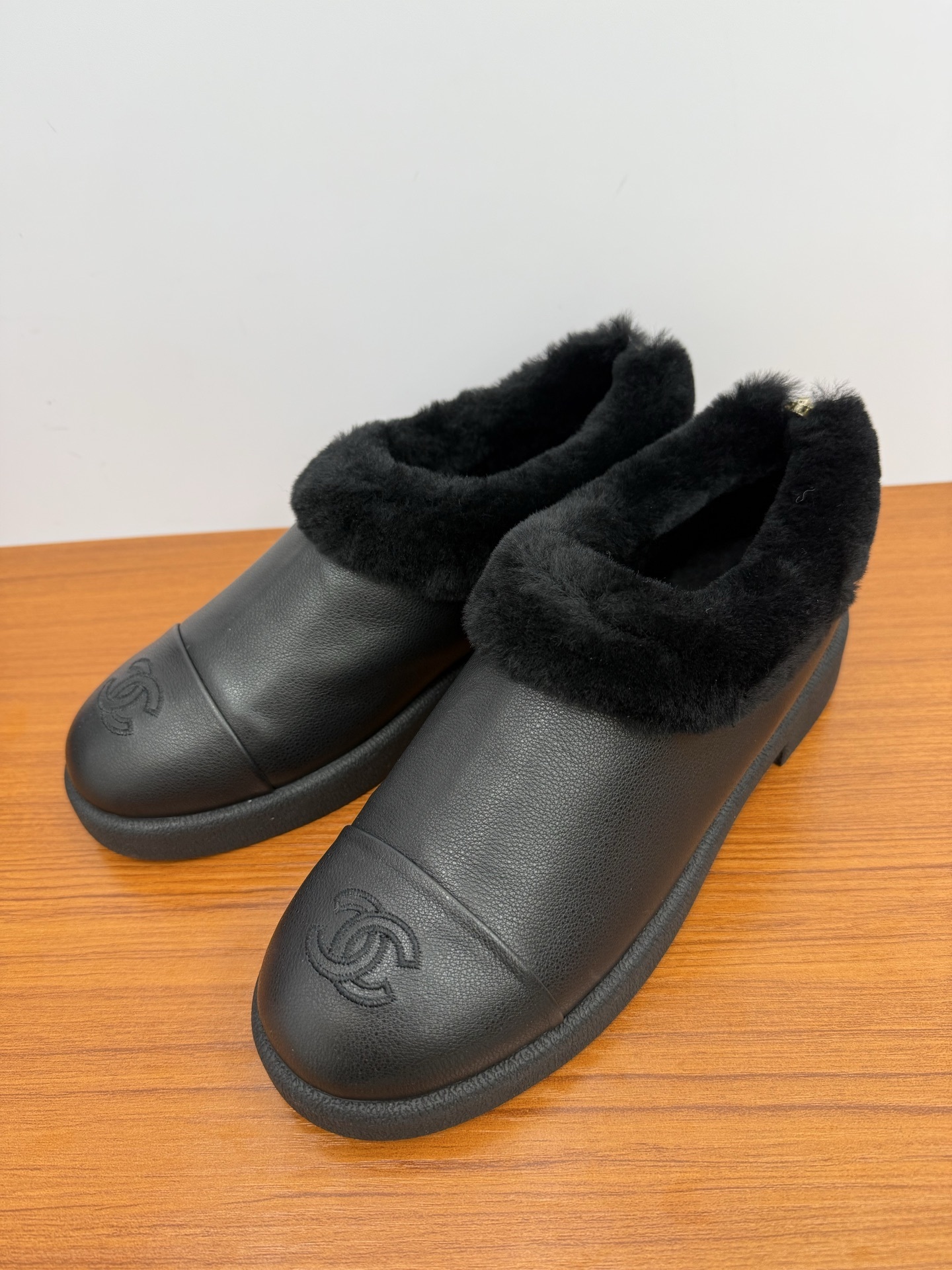 Pair of black leather women's mules with thick black fur lining and embroidered CC logo on the toe - Hình 3