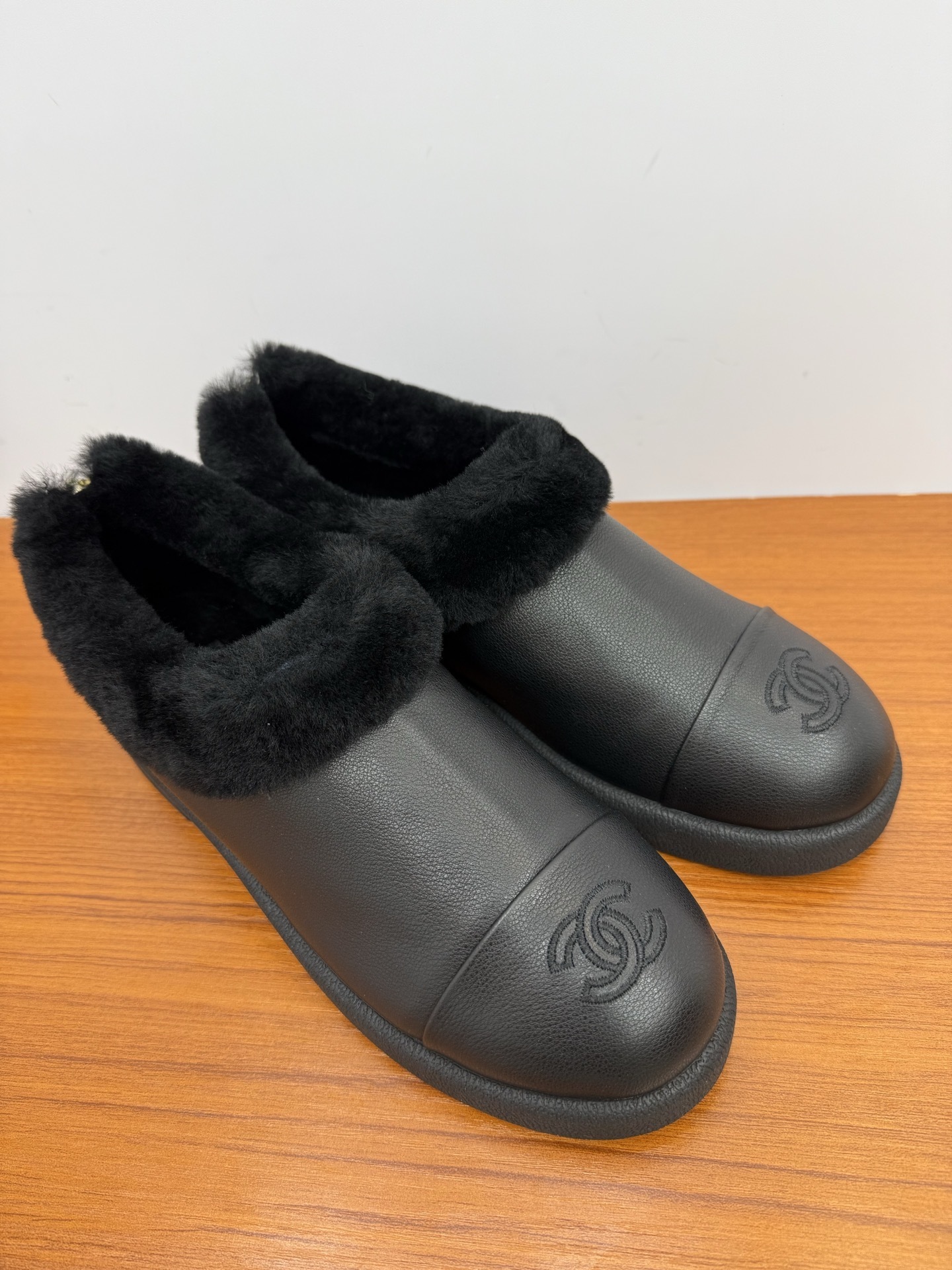 Pair of black leather women's mules with thick black fur lining and embroidered CC logo on the toe - Hình 2