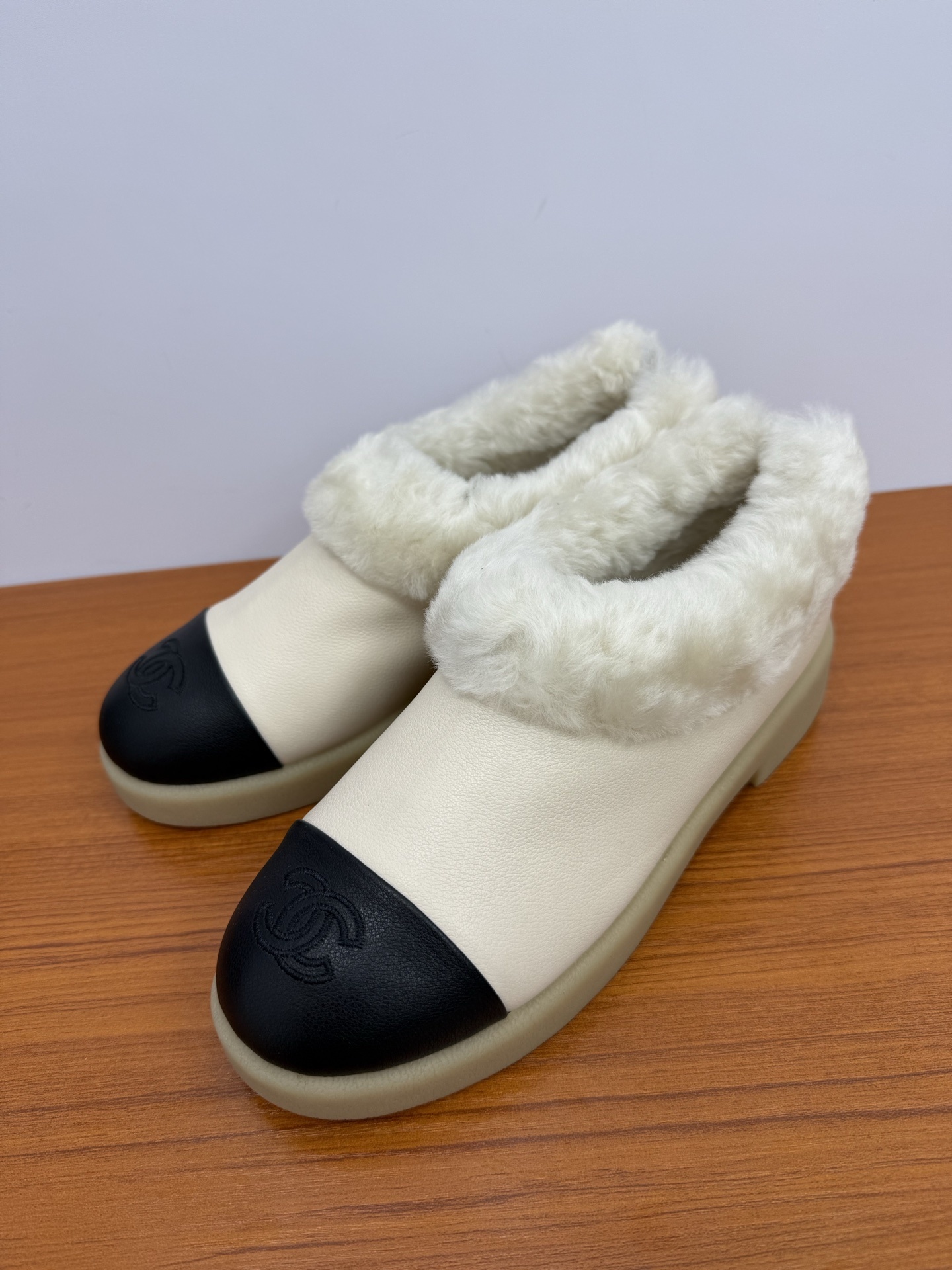 Pair of white and black luxury leather loafers with white fur lining and embossed logo on toe cap - Hình 3