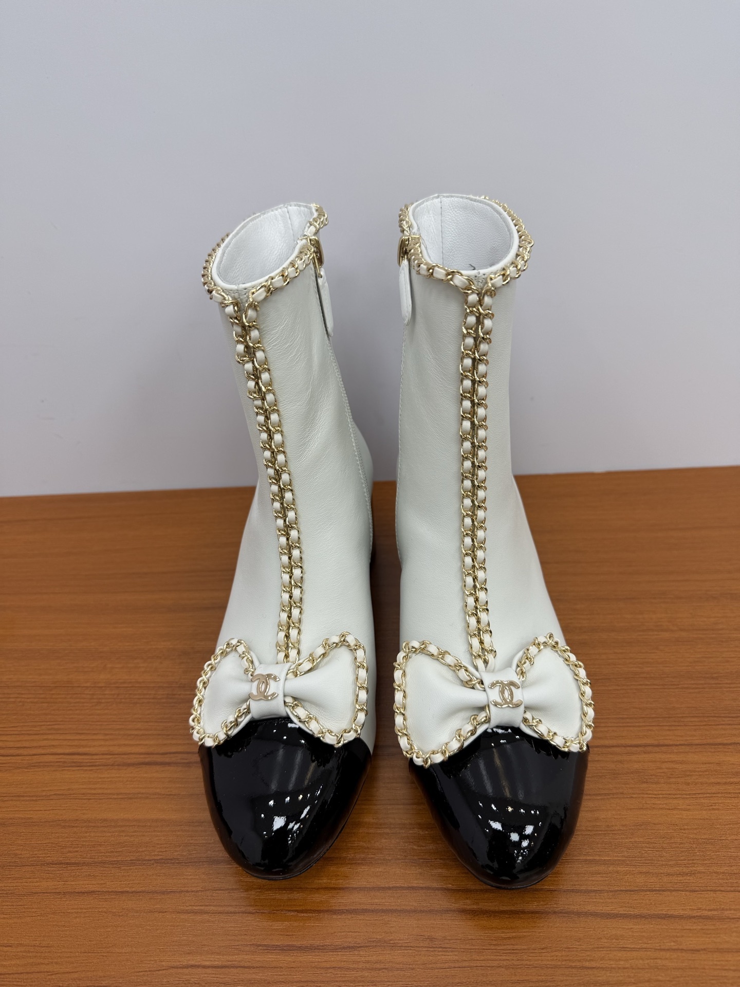 Elegant White & Black Cap-Toe Ankle Boots with Gold Chain Bow