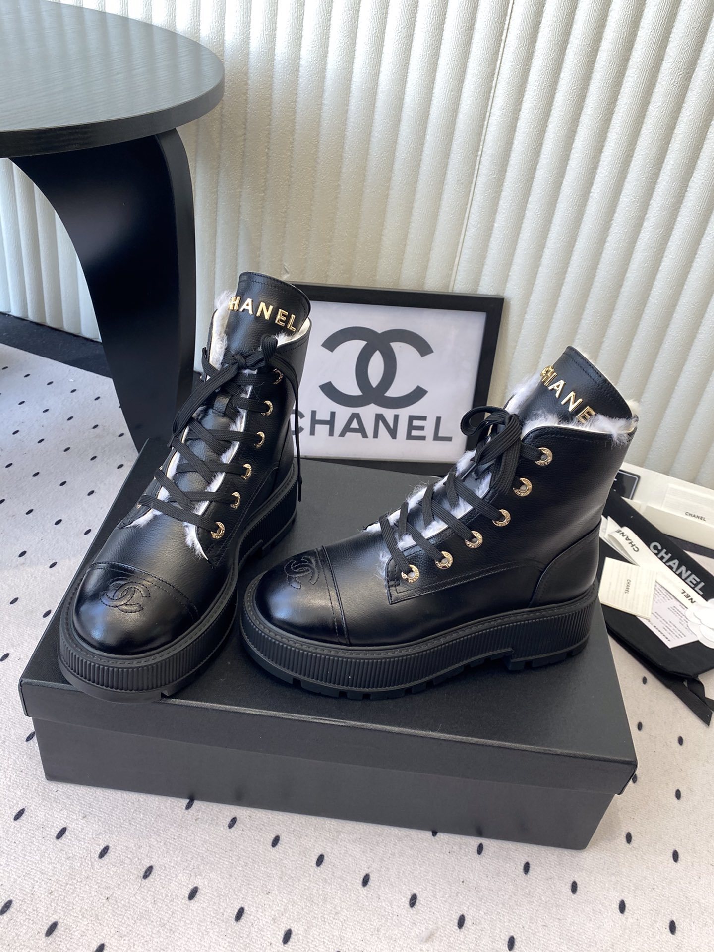 Chanel black leather lace-up combat boots with white shearling lining and gold-tone hardware on a black box. - Hình 8